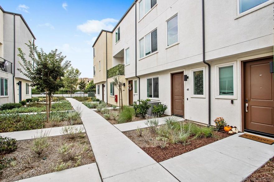 Welcome to this like-new townhome built in 2022, offering modern design, energy efficiency, and a highly convenient location. This spacious four-bedroom home features an open and airy floor plan with one bedroom and full bath on the entry level and three bedrooms upstairs. The contemporary kitchen includes quartz countertops, upgraded cabinetry, stainless steel appliances, and a large island that opens to the living and dining areas, perfect for entertaining. Additional highlights include luxury vinyl plank flooring throughout the main living spaces, a two-car garage, and fully paid solar for low utility costs. Located in the well-maintained La Brisa community, residents enjoy a low HOA, green turf common areas, and beautiful surroundings. VA and FHA approved, this home also offers a rare opportunity with an assumable VA loan at 4.75%, making it an exceptional value in today’s market. Conveniently situated near major freeways, shopping, and dining, this move-in-ready home combines modern comfort with everyday convenience.