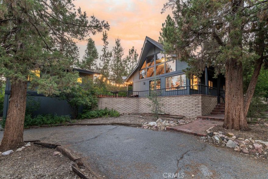 GORGEOUS CUSTOM CHALET + ADU IN WHISPERING FOREST, AT A SWEET PRICE!  The Walk and Drive Score on this one is EXCELLENT!  Within 0.3 miles (8 minute walk) from the National Forest at the end of the street, 1.7 miles from the lake, and approximately 1 mile from year-round fun at the Convention Center (Oktoberfest, Wyatt's, Farmer's Market), trailhead to the new paved pedal path and boardwalk through the Stanfield Marsh Wildlife and Waterfowl Preserve, Big Bear Snow Play and Raceway (go-carts), and dining––the location of this cabin is so great, and short-term rental guests rave about it too! Situated on a large corner lot surrounded by mature trees and shrubs, with plenty of parking space including a wraparound driveway and a 2-car garage.  Above the garage is a spacious ADU with an updated kitchenette, dining area, bedroom and bathroom.  In the main cabin, the great room boasts a wall of windows, vaulted wood and beam ceilings, a super cool mid-century modern wood burning stove surrounded by an extra long brick hearth offering additional seating. Game night or mealtime, from the living room to the kitchen and open dining, enjoy the convenience of getting to stay connected with your loved ones!  Or enjoy a break and retreat to the upstairs loft with its library-like shelving, or to the master suite!  Downstairs on the main level, there is another spacious bedroom with a lovely "reading nook", and a huge bathroom.  Outside there is plenty of space to lounge, including a relaxing and private hot tub to enjoy peaceful mornings or evening stargazing! Whether you're seeking your own slice of paradise for a personal retreat, a short-term rental investment, or a full-time residence, this property offers incredible flexibility. Live in one unit while renting out the other for supplemental income, or maximize its potential as a full rental. This is a home you simply must see- schedule your showing today!