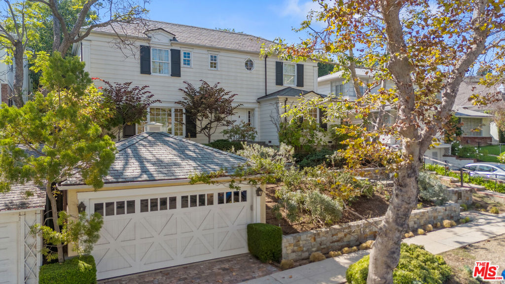 Welcome to 643 Westholme Avenue, a charming Colonial in the Little Holmby area of Los Angeles, designed by acclaimed architect Frederic Wallace and meticulously reimagined by the current owner. This home spans an impressive 4,800 square feet, with an 800 sq ft art studio/office, crafted by noted architect Frederick Fisher, all situated on an elevated 8,555 square foot lot offering classic California indoor/outdoor living! Step inside to discover a seamless blend of tradition and modern elegance. Warm toned hardwood floors flow throughout the home, featuring a light filled living room, a classic fireplace, and perfect ambiance for gatherings. A sunny dining room flows to the cooks kitchen offering built-ins, premium appliances including Sub-Zero, Miele, and a Wolf range and cozy breakfast area with upholstered banquette perfect for family meals. A cozy family room, complete with a fireplace, custom built-ins opens and wall of glass opening to the flagstone patio and meticulously designed terraced garden, designed by noted landscape architect Laurie Loyce. Enjoy outdoor entertaining at its finest, offering a fire pit, fountain, kitchen, pergola and many citrus and fruit trees. A magical outdoor dining area beautifully accented with outdoor lighting for many al fresco evenings. This home offers 5-bedrooms, 5.5-bath, all en suite, providing privacy and convenience. The serene primary suite boasts vaulted ceilings, built-ins, a luxurious bathroom with a separate shower and tub, and Toto toilet. A private balcony overlooks the lush gardens. Perfectly sited amongst this idyllic garden setting is a separate 800 sq ft studio designed by Frederic Fisher with soaring vaulted ceilings, skylights, and a mini kitchen and bathroom offering a variety of uses - art studio, home office, guest house, screening space, etc...Additional features include a laundry room, water filtration system, 2-zone HVAC, a 2-car garage, but no direct access to the house.- perfect for a family, or anyone wanting true haven offering privacy, elegance, and sophistication. Adjacent to UCLA and Beverly Hills and central to all LA has to offer!