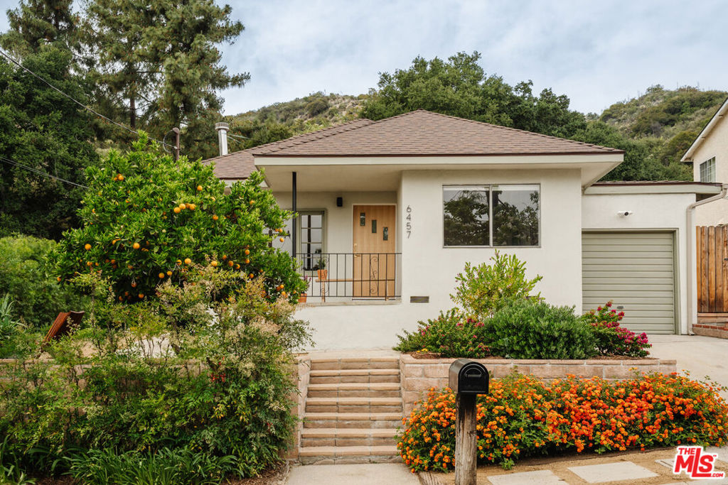 Tucked on a quiet street against a lush hillside backdrop, this stunning artist's retreat with sparkling pool and bonus studio offers tranquility, character, and thoughtful updates throughout. The home balances rustic charm with modern comfort, featuring warm wood floors and abundant natural light. Step into a spacious living room with soulful vibes, large picture windows, and a striking vintage conical fireplace. The light-filled chef's kitchen is a true delight, with a row of skylights, updated top of the line appliances, and plenty of prep space. The generous primary bedroom includes ample storage and a stylishly updated bath, which flows into a second bedroom with flexible potential. A separate entrance, providing an additional 200sf of bonus space, leads to a beautifully finished artist's studio flooded with natural light and ideal for creative work, a home office, or guest space. Outside, the private backyard brimming with drought tolerant landscaping is an entertainer's dream, with multiple seating areas and a sparkling pool, perfect for summer days ahead. All this just minutes from the trailheads of Angeles National Forest and the charm of Montrose Village, known for its shopping, dining, and vibrant weekly farmers market. A rare find with heart, soul, and style in a scenic neighborhood. Some upgrades include: freshly refinished and re-plumbed pool, new roof, rewired electrical + panel, all new gas lines, new water heater, and much more.