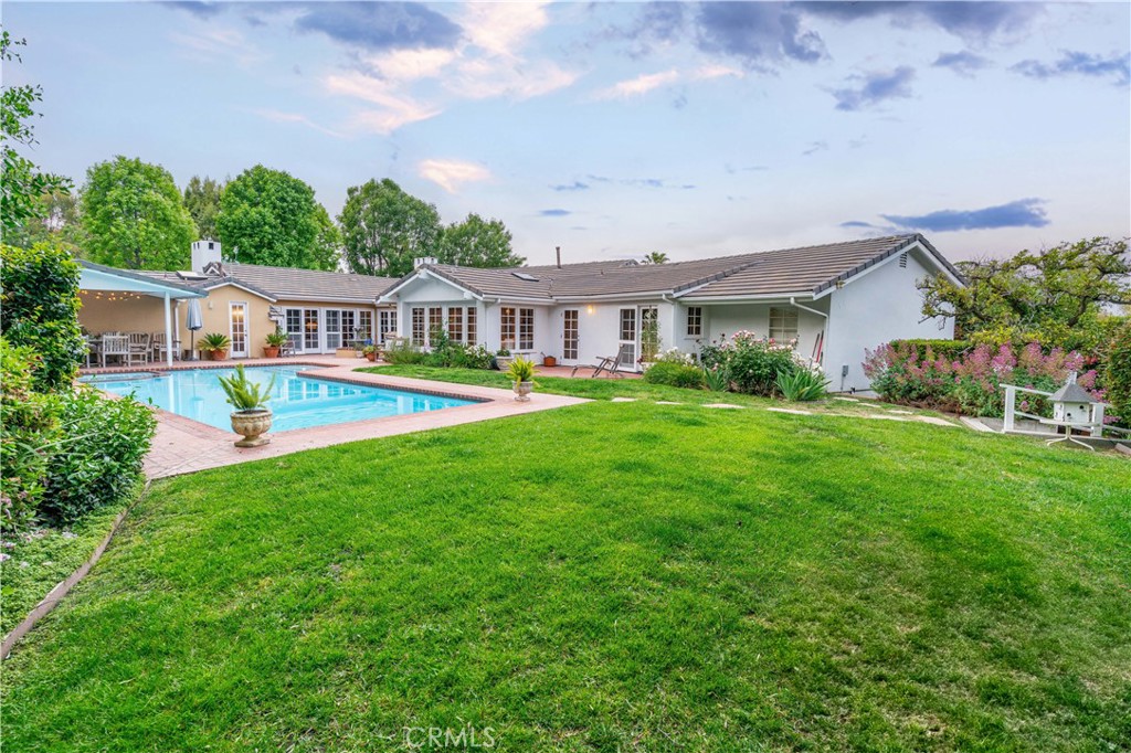 Prime location! This classic Rolling Hills ranch home is conveniently located on a quiet leafy street. No neighbors across the street, this property offers privacy and solitude with the main noises being birds happily singing! Trees, trails and tranquility await, and this sanctuary stands ready for its new owner to experience what makes living behind the gates so extraordinary! Walking through the front door, you are greeted by multiple french doors that look out on the verdant backyard with pool and spa. The home has 4 bedrooms, 3 baths and also has a guest house (approx 340 sq ft and not included in square footage) on the lower pad, nestled among lemon, lime, persimmon, peach and apricot trees. Living room and Family room are situated on both sides of the entry and a kitchen with center island looks out onto a third living space. Canyons form the property boundaries on both sides of the property. Living in Rolling Hills is unlike any other community in southern California, so check out this unique family home and experience the comfort and solace and find your place!