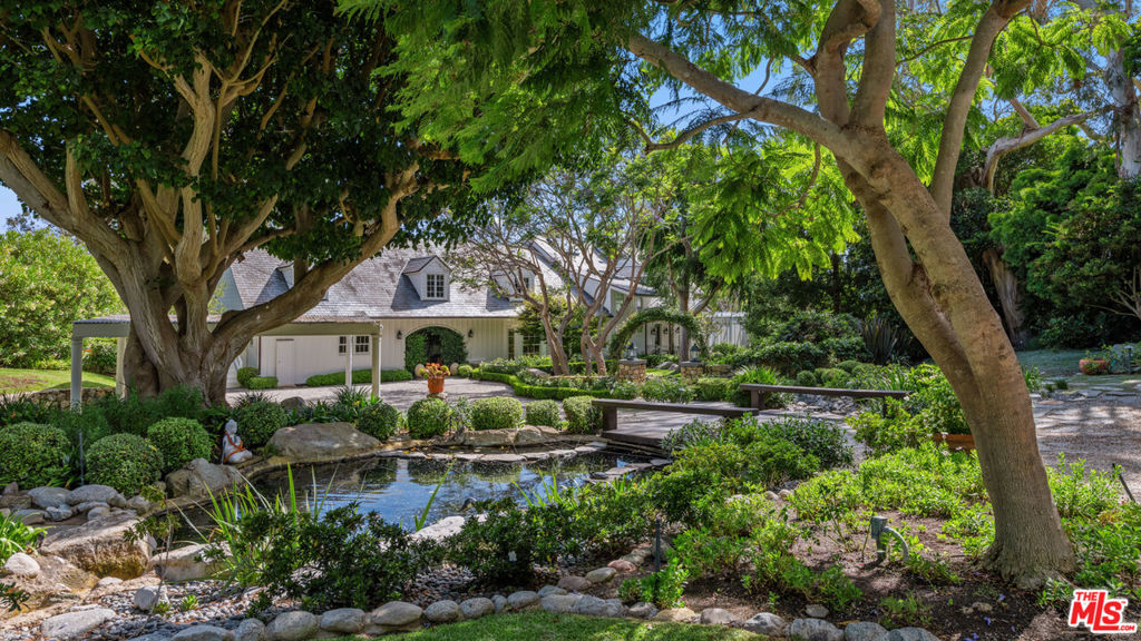 Nestled at the pinnacle of Point Dume's most coveted street lies this extraordinary private estate. Secluded behind gates, atop a majestic ocean bluff, architect Peter Choate's masterful design reveals a seven-bedroom, six-bathroom residence on 1.5+ acres. With pristine beauty this unparalleled sanctuary boasts orchards, gardens, a pool, and a private door to exclusive Little Dume Beach Access. Upon arrival, guests are greeted by majestic coral trees and cascading bougainvillea leading to the 100-foot driveway, lined with mature eucalyptus trees and pots of illuminated white roses, with a bridge over babbling brooks and serene ponds. The farmhouse-inspired facade in fresh white, complemented by a slate tile roof and copper accents, exudes elegance. Inside, panoramic views of the ocean, Catalina Island, and lush orchards captivate. Oak wood floors and French doors enhance the seamless indoor-outdoor lifestyle. The chef's kitchen dazzles with white cabinetry, a Wolf six-burner range, Sub-Zero refrigerator, wine refrigerator, and honed Calcutta marble countertops. Nautical-inspired brass fixtures illuminate the space, complementing a charming eat-in nook with a curved built-in bench. The gracious living room features a wood-burning fireplace and beamed ceilings, opening to an outdoor paradise. Manicured lawns, specimen trees, and landscaped orchards surround a pool, a bluestone gas firepit, with ocean-view decks that provide an idyllic setting for entertaining. Upstairs, the tranquil primary suite boasts dramatic ocean views, 11-foot ceilings with wood beams, and a gas fireplace. Four additional bedrooms offer unique features such as Juliet balconies and dormer windows, each capturing breathtaking vistas. This estate epitomizes the coveted Point Dume lifestyle, blending unparalleled luxury with natural beauty and exclusive amenities offering a rare opportunity to embrace coastal living at its finest. Additional highlights include a laundry room, guest suites with garden views, a sunlit conservatory and property generator. This rare wonderland promises an unparalleled Malibu experience.