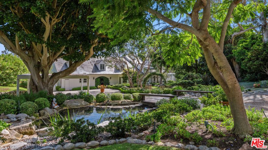 Nestled at the pinnacle of Point Dume's most coveted street lies this extraordinary private estate. Secluded behind gates, atop a majestic ocean bluff, architect Peter Choate's masterful design reveals a seven-bedroom, six-bathroom residence on 1.5+ acres. With pristine beauty this unparalleled sanctuary boasts orchards, gardens, a pool, and a private door to exclusive Little Dume Beach Access.    Upon arrival, guests are greeted by majestic coral trees and cascading bougainvillea leading to the 100-foot driveway, lined with mature eucalyptus trees and pots of illuminated white roses, with a bridge over babbling brooks and serene ponds. The farmhouse-inspired facade in fresh white, complemented by a slate tile roof and copper accents, exudes elegance. Inside, panoramic views of the ocean, Catalina Island, and lush orchards captivate. Oak wood floors and French doors enhance the seamless indoor-outdoor lifestyle. The chef's kitchen dazzles with white cabinetry, a Wolf six-burner range, Sub-Zero refrigerator, wine refrigerator, and honed Calcutta marble countertops. Nautical-inspired brass fixtures illuminate the space, complementing a charming eat-in nook with a curved built-in bench. The gracious living room features a wood-burning fireplace and beamed ceilings, opening to an outdoor paradise. Manicured lawns, specimen trees, and landscaped orchards surround a pool, a bluestone gas firepit, with ocean-view decks that provide an idyllic setting for entertaining.     Upstairs, the tranquil primary suite boasts dramatic ocean views, 11-foot ceilings with wood beams, and a gas fireplace. Four additional bedrooms offer unique features such as Juliet balconies and dormer windows, each capturing breathtaking vistas. This estate epitomizes the coveted Point Dume lifestyle, blending unparalleled luxury with natural beauty and exclusive amenities offering a rare opportunity to embrace coastal living at its finest. Additional highlights include a laundry room, guest suites with garden views, a sunlit conservatory and property generator.     This rare wonderland promises an unparalleled Malibu experience.