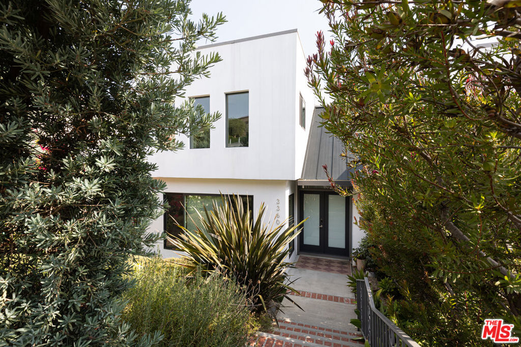 Peaceful, private, and hedged 1960s Los Feliz 3-story Contemporary masterpiece evoking Palm Springs vibes. This recently renovated magnificent showstopper boasts 4 bedrooms, 4 baths, stunning views, incredible bonus space, and even more possibility for expansion and upside. Drama and wonder can be found here at every turn. To begin, the stately double-door entryway features original Terrazzo floors, a dramatic sweeping staircase, and soaring pitched ceilings. A generous step-down living room sets the tone for easy, sophisticated living. Prime for entertaining, an elegant formal dining room flows seamlessly through sliding doors out to an absolutely awe-inspiring deck which is anchored by a breathtaking view of the surrounding hills and mountains and also includes a built-in hot tub, sauna, and multiple congregating areas to relax, lounge, and play. A bright chef's eat-in kitchen, spacious family room, and guest powder room complete the primary level. The second level features a luxurious primary suite boasting sunny, harmonious views, walk-in closet, and en suite bathroom with dual sinks and custom tile. Three additional generously-sized bedrooms and two more full bathrooms complete the upper level. The lower level features a dedicated laundry room, plenty of storage, and an additional expansive bonus room downstairs (approx 400 sf) which could be transformed into whatever your heart desires - a perfect second family room, screening room, game room/playroom, gym, or guest quarters. Two-car garage with direct access to the home. A stone's throw to Los Feliz Village and a plethora of local favorites including Alcove Bakery & Cafe, All Time, Encanto, Jeni's, Little Dom's, Lou's Wines, Maru, and MessHall. Griffith Park trails, the Observatory, easy freeway access, and concerts at The Greek are always at your fingertips. Lushly landscaped and completely private, this dynamite home is truly the ultimate sanctuary.