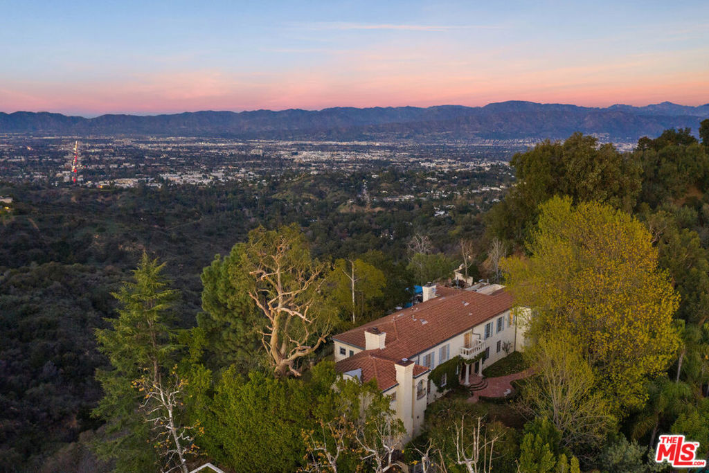 BHPO Gated Celebrity Compound is located off a long-secluded driveway with expansive views. It is located on over 32,000 square foot lot with jaw-dropping 180-degree views, spanning city and canyon. Incredible bones with great volume, ceiling height, and layout. Magical sunrise to sunset, on estate rich with old-world charm and pedigree. Living space includes a grand foyer, great room, library, sitting room, owner's suite, formal dining room, his and hers offices, garden room, breakfast room, and assistant's quarters. 6 bedrooms and 7 1/2 baths filled with character and love, attention to detail with a craftsman's touch. The expansive lot is lushly curated and landscaped with verandas, sitting areas, and gardens, all seamlessly blended with nature while capturing the majestic views. This is a rare opportunity with ultimate privacy, complete with garage, workshop, and motor-court parking for 12 cars. This home is not part of the," supporting cast," but a leading lady!