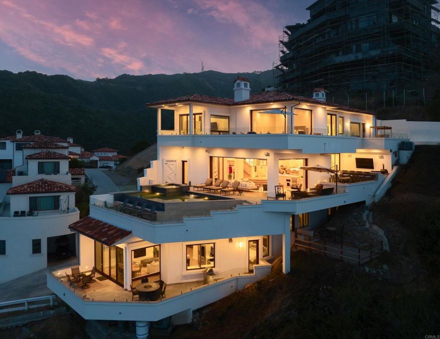 A rare jewel perched above the Pacific, 211 Mar de Cortez is Catalina Island’s newest and most prestigious cliffside estate, a 2024 architectural triumph within the coveted private community of Hamilton Cove. This over 7,000-square-foot oceanfront residence offers an unparalleled blend of modern sophistication, coastal serenity, and effortless elegance. Commanding breathtaking 180-degree views of the sea, the iconic Catalina Island Casino and Avalon city lights from its dramatic cliffside vantage point, this seven-bedroom sanctuary has been masterfully crafted for both lavish entertaining and intimate retreat. Walls of glass open to a 3,700 square feet of outdoor living space, with multiple terraces, alfresco lounges, outdoor BBQ with pizza oven, and a resort-caliber ocean view pool blur the line between interior refinement and natural splendor. Inside, every detail is a study in luxury, from soaring ceilings and designer finishes to a private elevator connecting all levels. A state-of-the-art home theater offers a cinematic experience that rivals the finest movie theaters. This estate also features a fully equipped 2,000 square foot 3-bedroom 2-bath attached guest house with a dedicated private deck. Set within the gated community of Hamilton Cove, renowned for its Mediterranean architecture, private beach access, and resort-style amenities, 211 Mar de Cortez is not just a home, but a generational legacy perched high above the sea.