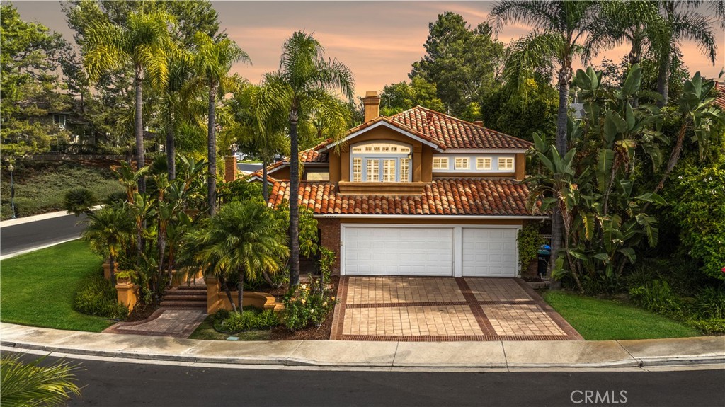 Rare and Private Corner Lot that measures over 10,000 square feet in the prestigious guard gated community of Canyon Crest’s Gallery Collection. This Mediterranean style home has one of the most impressive and serene backyard spaces that you will find. Custom brick and concrete architectural hardscape surround the pebbletec pool and spa, outdoor gas fireplace with mosaic tile and a top tier lounge area with a stunning water feature that streams down into the pool. The grass area and lush landscaping surround the entire property, creating total privacy and seclusion. This exceptional home presents towering vaulted ceilings, elegant stone inlay floors, Dual Pane wood clad windows with beautiful wood casings, plantation shutters, wrought iron stair rail, 3 gas fireplaces and an exceptional open concept floor plan with a downstairs bedroom/office and full bathroom. Your stunning chef’s kitchen overlooks the massive rear yard and features custom cabinetry, Sub Zero refrigeration, commercial Decor range and lime stone countertops. Traversing upstairs, you will find a huge bonus room with vaulted ceilings, two generous guest bedrooms that share a jack and jill bathroom and your stunning primary suite. The primary bedroom showcases a private balcony, a large walk-in closet and a luxurious remodeled primary bathroom with a soaking tub and separate glass enclosed shower. The Canyon Crest community offers unparalleled amenities including but not limited to: A beautiful clubhouse, fitness facility with dry saunas, tennis & pickleball courts, an amazing lap pool and kids pool, basketball court, tot lot, BBQ area, green space, billiards room, plus membership to Mission Viejo Lake.