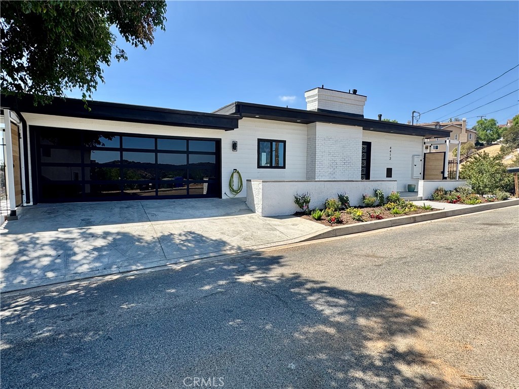Welcome to your Sky House retreat in the picturesque Woodland Hills neighborhood, where breathtaking valley and mountain views await. This enchanting multi-level, Mid-Century Modern style home is perched high above the San Fernando Valley, south of Ventura Blvd, offering a perfect blend of artistic design and natural beauty. Step inside to discover expansive living spaces filled with warmth and character. The inviting living room features a cozy fireplace and opens to one of several decks ideal for enjoying the stunning vistas and peaceful surroundings. With three spacious bedrooms and two versatile suites, there's ample space to relax, create, and entertain. The chef's kitchen is designed for culinary creativity, offering generous storage, pantry space, and an intuitive layout perfect for both entertaining and quiet evenings at home (all equipped with soft closing drawers and cabinet doors). Both levels each have their own attached decks offering an additional 800 square feet of exterior space per level. The open-concept living and dining areas ensure easy flow for gatherings. The primary bedroom is a true haven, complete with an attached sitting deck with panoramic views, a walk-in closet, and a stylish en suite bathroom featuring dual vanities, a free standing bath tub, heated towel rack and a large frameless glass shower.