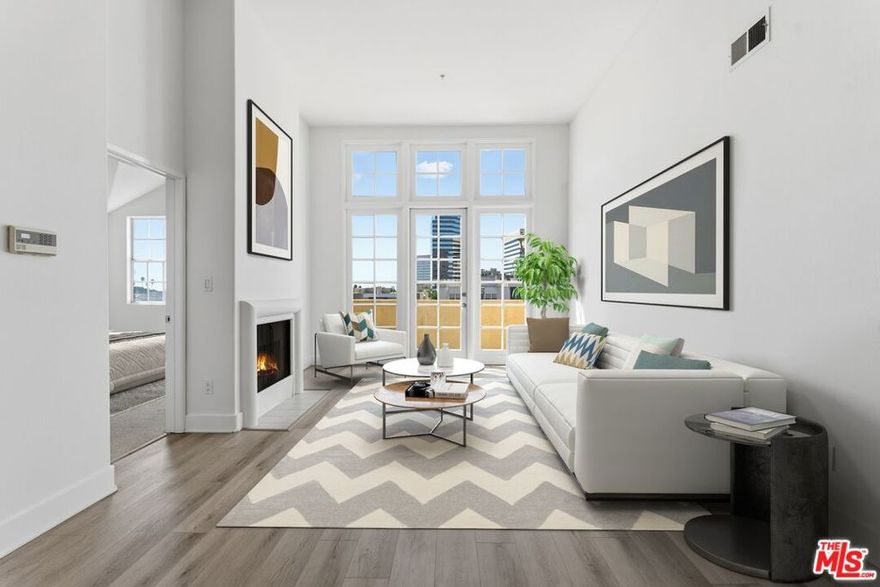 Poised above the city, this top-floor penthouse offers an elegant expression of Westside living. Soaring vaulted ceilings and natural light frame an open, airy layout centered around a warm fireplace and an inviting living space. The chef's kitchen combines form and function with stainless-steel appliances, generous cabinetry, and seamless connection to the main living area; perfect for effortless entertaining. The primary suite evokes calm sophistication with a spacious walk-in closet and a dual-vanity bath. A second en-suite bedroom provides flexibility for guests or a refined home office. Step outside to a private balcony with sweeping city views, ideal for morning coffee or evening sunsets. Additional features include in-unit laundry, secure building entry, and gated parking. Perfectly positioned near Brentwood, Santa Monica, and the vibrant Sawtelle dining scene, this residence blends contemporary style, everyday comfort, and exceptional convenience in one elevated home. Lease offered at 13 months or more.