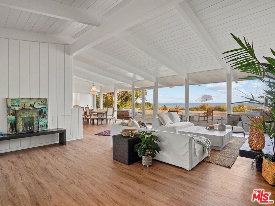 A rare and profound opportunity to purchase one of the best beachfront properties in Malibu! This newly updated mid-century home is situated in the middle of Broad Beach and boasts approximately 73 feet of beach frontage. Private and gated, this beachfront oasis embodies coastal living with floor-to-ceiling windows, high vaulted ceilings, and breathtaking ocean and whitewater views throughout. Pass through a freshly landscaped entryway into a living and dining area that flows seamlessly outside to a private, sandy beach with an exceptionally large covered patio with windbreak, perfect for relaxing and entertaining. The kitchen enjoys ocean views through a picture window, a breakfast bar, and new appliances. There are five bedrooms on the entry-level including an ocean-view suite, an en-suite bedroom with a separate entrance currently used as a gym/office, an additional beachfront bedroom, and an attached guest suite with a separate entrance. The entire upper level is dedicated to the spacious master suite featuring whitewater views through massive windows, a large wooden sun deck, and dual bathrooms with a soaking tub and shower. This classic Malibu beach home is casual oceanfront living at its best with new updates to suit your every need. There are plans in process at the City of Malibu for a new approximately 4,170 square foot home with much of the underlying work completed. Enjoy, update, or build your dream home on Broad Beach Road!