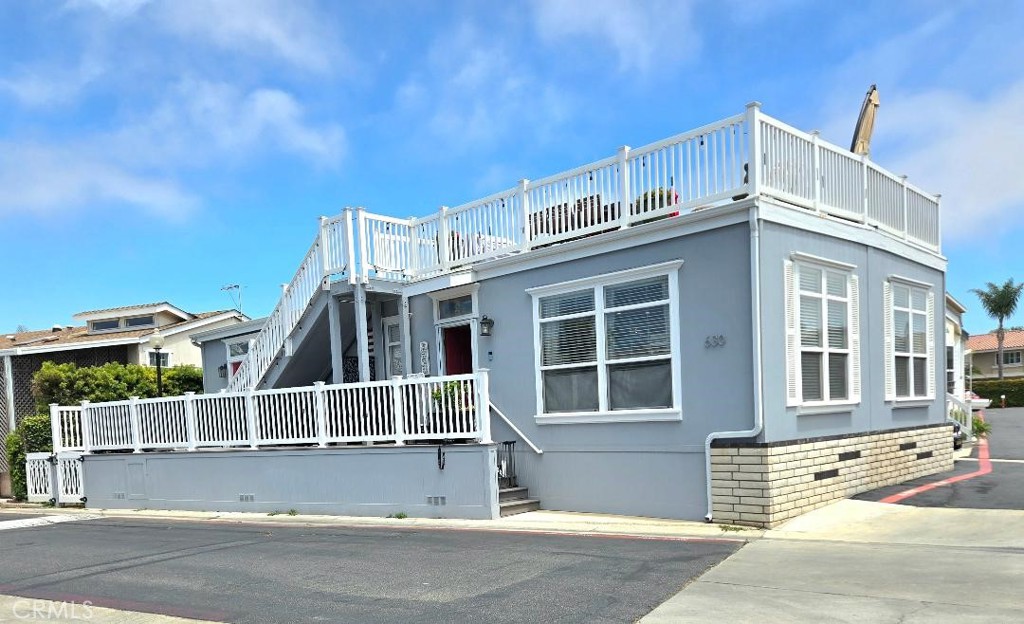 Across the street from the OCEAN!!! Welcome to your slice of paradise in the heart of Surf City USA. Nestled on a prime corner-lot less than a block from the sand, this stunning 2015 Fleetwood home offers an unbeatable blend of relaxed beachside living and modern luxury. With direct access through the back gate to the oceanfront, you’ll never have to travel far to live your dream with this is vacation living, every day of the year. Step inside and you’re greeted by soaring 9-foot ceilings and elegant crown molding. Rich bamboo hardwood floors add warmth and style, complementing the natural light through double-pane windows. This 3-bedroom, 2-bathroom home is as practical as it is beautiful, with one full bath and one three-quarter bath designed for comfort and convenience. The kitchen is a chef’s delight with a built-in pot filler, beverage fridge, and all modern appliances. A custom pantry provides plenty of storage, and recessed lighting throughout adds a contemporary touch. French doors off the master suite leads to your own private patio, where morning coffee meets ocean breezes. The master bedroom also features a spacious walk-in closet. Life here extends seamlessly outdoors with two separate patios, one upstairs and one down. Ideal for entertaining. The rooftop deck is a true sanctuary, offering views that stretch across downtown Huntington Beach, with over 624sqft of waterproof, and cool anti-slip deck area to party with friends. The deck is equipped with a water line, electricity, and propane connection perfect for a BBQ or cozy fire pit under the stars. The homes’ exterior is as well-maintained as the inside, with brand-new outdoor paint and gutters completed in February 2025. Waterproof enclosed front stairs provide both durability and style, while the professionally landscaped dog run with pet-grade turf makes this the perfect home for four-legged family members. Additional perks include built-in rear storage, a large, attached storage area, and covered parking with two carport spaces, great for storing your beach bikes and surfboards. Modern features such as a tankless water heater, central heating, and air conditioning ensure year-round comfort. Also enjoy the gated pool and spa only footsteps away. From your rooftop deck, enjoy thrilling flyovers during the Pacific Airshow, and 4th of July fireworks, and take in world-class events like the US Open. The Huntington Beach Pier is less than a mile walk. Space rent is only $3,700 a month.