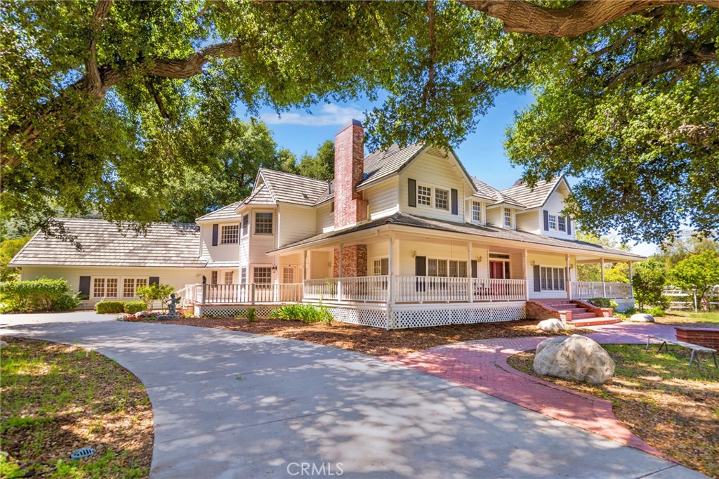 Beautiful Sand Canyon Custom gated estate home with guest house. Incredible flat land with over two acres of yard area and gorgeous Oak trees on the property. The amenities include gated main home with 5534 sq. ft. and 1299 sq. ft. guest home, a turnaround driveway, swimming pool and spa, private back patio & grass area, BBQ area, wine cellar, three car attached garage at the rear of the main house and two car garage at guest house. Peaceful front yard area with sensational pergola area spanning over 60 ft. The home has a classic wrap around front porch and a great floor plan that includes five spacious bedrooms and five bathrooms in the main house, two family rooms, hardwood floors, bar/library- game room, separate guest house with kitchen, two rooms-upstairs/office, bathrooms and a large entertainment or work out fitness room area below with a two car garage. The main kitchen is equipped with a Viking range, storage/cabinet space, breakfast bar area, stone counters and opens to family room with ample windows making it light and bright. Huge primary bedroom with bathroom large vanity area, soaking spa tub and sitting area. Spectacular private estate home in Sand Canyon with room to entertain and enjoy!