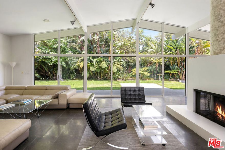 This architectural 4-bedroom, 3-bathroom home with an office and bonus room is a quintessential example of classic mid-century modern design, ideally situated on a quiet cul-de-sac in sought-after Malibu West. Just moments from Vintage Market and the private Malibu West Beach Club, residents enjoy exclusive access to tennis courts and a pristine stretch of coastline. Designed in the iconic atrium style, the home welcomes you through a bright courtyard into a dramatic space featuring post-and-beam construction, soaring ceilings, and expansive walls of glass that blur the line between indoors and nature. The open-concept living area centers around an architectural fireplace, with limestone floors and a sleek, gourmet kitchen outfitted with stainless steel appliances.The serene primary suite includes a sunken shower, spacious walk-in closet, and calming views. Three additional bedrooms offer flexibility, with one set apart for added privacy, ideal for guests, a home office, or multigenerational living. A den and a generous family room complete the home's versatile layout.Outside, a built-in BBQ, grassy lawn, private hot tub, and peaceful surroundings create the perfect setting for relaxed California living.