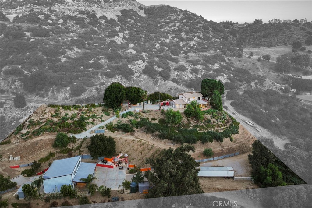 Private and Custom Box Canyon Estate on 1.6 Acres! A stunning primary home artistically blends art and nature featuring 2 bedrooms, loft/office space, 2 bathrooms and panoramic views from either the giant balcony or spacious covered patio. The lower parcel features a high-ceiling all-steel workshop with 3 roll-up doors capable of parking an RV inside and inclusive of 240V-3 phase power, utility room, and half bath, while upstairs, an ADU offers 1 bedroom, 1 bathroom, a full modern kitchen, and a living room with panoramic views ideal for guests, rental income, or a private retreat.The property is perfect for multi-generational living, rental income, or a dedicated creative workspace/studio. Enter through remote-operated handcrafted gates and experience the artistry throughout, from the wood-burning fireplace, imported Italian stovetop, and custom powder-coated cabinetry to the expansive balconies with breathtaking canyon views. Designed for entertaining, the property includes a Tuscany-inspired outdoor space with a pizza oven, smoker, bell tower, vineyard with 80 cabernet vines, olive and fruit trees, and a stunning patio with natural stone floors, antique glass cabinets, and a mosaic-inlaid countertop. Additional features include multiple water storage tanks, sheds, an insulated storage container, and a spacious garage. Offering the perfect blend of seclusion, inspiration, and functionality, this extraordinary estate is just minutes from the 118 fwy yet feels like a world of its own. Live, create, and entertain in a home where art, nature, and imagination unite. Schedule your private tour today!