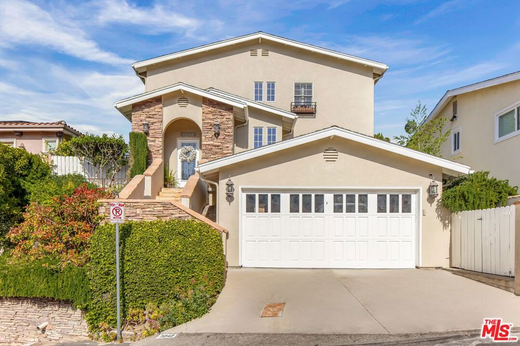 Crisp canyon air, awe-inspiring views, and a layout tailored for modern living define this radiant residence in the hills of Sherman Oaks. Framed by stacked stone and manicured landscaping, the entry unfolds to sunlit interiors of generous proportions anchored by light-toned oak flooring. Formal living and dining rooms extend seamlessly into the core of the home -- an open-concept great room with a wood-framed slider to the backyard. The kitchen features a central island, stainless steel appliances including double wall ovens and a gas cooktop, a prep sink, and quartz countertops. A built-in breakfast nook, wrapped in an enchanting bay window, invites immersion in the surrounding greenery. In the adjacent family room, a gas fireplace provides a cozy, sunlit gathering space. Designed with both relaxation and entertainment in mind, the outdoor living area includes a generous stone patio ideal for al fresco dining or lounging and a newly installed turf lawn surrounded by mature hedges. Enhancing the property's connection to the natural environment, far-reaching views stretch from the lush canyon to distant city lights and a meandering path descends the hillside. The two-level floor plan provides thoughtful separation and flexibility. On the main level, two well-appointed bedrooms share a full bath -- ideal for guest accommodations, office space, or extended stays. Upstairs, the expansive primary suite features a Juliet balcony, dual closets, and a spa-like bath with a soaking tub, double vanities, and glass-enclosed shower. Two additional ensuite bedrooms and a dedicated laundry room complete the upper level with both functionality and style. Ideally positioned just minutes from Ventura Boulevard, with easy access to renowned dining, boutique shopping, and prestigious private schools including The Buckley School and Harvard-Westlake, this hillside haven presents a rare opportunity to experience elevated living in one of Sherman Oaks' most desirable enclaves.