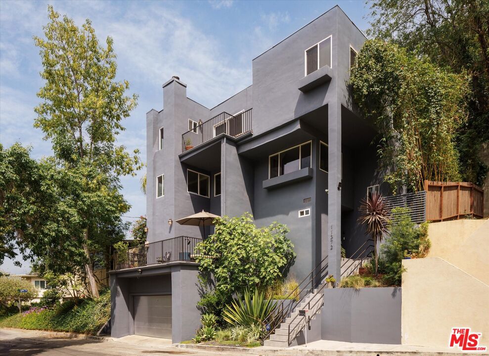 Tucked away at the end of a serene cul-de-sac in the "South of Ventura" area of Studio City, this warm modern multi level is elevated above it all, yet moments aways from the shops and restaurants on Ventura Boulevard. Offering sweeping views overlooking the Valley and surrounding hills, this thoughtfully designed home maximizes vertical space, giving you more square footage and providing terraces on every level. The first floor as you enter is an open concept great room that can be used as an entertainment level or a large professional office. It features a media room nook, a gas fireplace, a wet bar with built-in beverage fridge, and large sliding glass doors that lead to a sunny terrace. The second floor reveals the living room, dining room and kitchen filled with natural light and dramatic views that stretch from the valley to the distant mountains. A stunning glass conservatory provides a charming view of mature greenery. Outside a spacious deck extends directly from the kitchen, ideal for barbecues, alfresco dining, or relaxing by the fire pit while a custom river-inspired waterfall offers soothing background ambiance. All three bedrooms are located on the top floor along with a full laundry room. The primary suite features southern exposure, a terrace, gas fireplace, a custom walk-in closet and a spa-inspired bath with breathtaking views. Two additional bedrooms share a full bath, making this level a perfect blend of comfort and privacy. Additional highlights include an oversized two car garage with lots of storage space and an EV charger. All this in coveted school district of Rio Vista elementary and Walter Reed Middle, just steps away from the charming shops and cafes of Ventura Blvd, this is Studio City living at its finest.