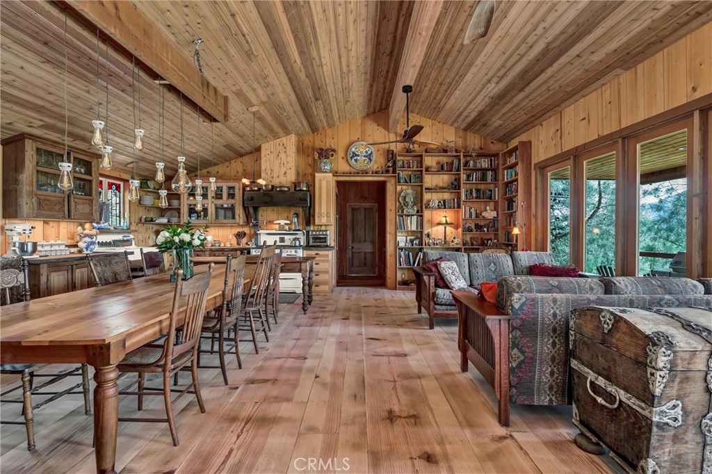 Nestled on 7 acres of forested serenity in the foothills of Mt. Hannah, this unforgettable home is a masterclass in character, craftsmanship, and curated design. Every inch has been thoughtfully imagined, blending historic European elements with rustic Northern California soul.
Step into the expansive great room to find locally milled pine floors stretch beneath soaring cedar ceilings. A custom light fixture, hand-built by the seller, illuminates the grand dining table, creating a warm and welcoming heart of the home. Leaded stained-glass windows bathe the space in dappled light, and bespoke details invite you to slow down and stay awhile. The kitchen has beautiful live-edge wood counters, farm sink and an antique Wedgewood stove. The primary suite is a private sanctuary, where 200-year-old Belgian stained glass doors lead to a luxurious bath. There, an antique claw-foot tub and vanity reclaimed from a French hunting cabin add depth and story to an already exceptional space. A new roof (2023) offers peace of mind, while the turreted architecture and panoramic forest views offer daily inspiration. Enjoy the bounty from the small orchard and maybe add a few animals to create your perfect country escape.