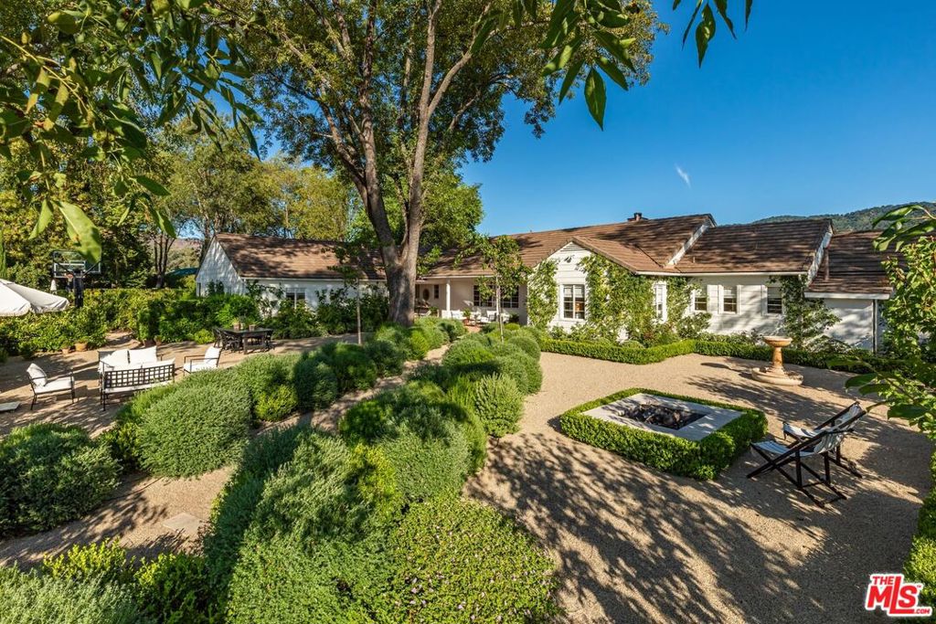 Welcome to Paradise Ranch, a 36.8-acre legacy estate where the beauty of Ojai meets the dream of living well. As you pass through the gates, you're instantly transported to a more intentional way of life, built around meaningful moments that last, in one of California's most coveted destinations. Nestled beneath the majestic Topa Topa Mountains, this rare offering is more than a property; it's a private haven where friends and family gather for long weekends, special occasions, and spontaneous escapes. At the heart of the compound stands an inviting, light-filled farmhouse, surrounded by lush lawns, white roses, lavender, stately cypress, and fruiting citrus, avocado, and olive trees. Sprawling flat fields invite your own flourishing vegetable garden; perfect for farm-to-table meals and weekend harvests. A charming guest house offers an idyllic retreat where loved ones feel at home. Wander to your private saloon, perfect for poker night, game day, or a nightcap. A sweeping heritage-style agricultural barn with an expansive workshop anchors the property with rustic charm and versatility. It's ideal for collectors, creatives, equestrians, or entrepreneurs. Just beyond sits an approximately 2,000-square-foot structure with electric and plumbing rough-ins, ready for whatever you envision: bunkhouse, office, studio, gym, or game room. Dream big, because there's room for it. Meandering trails lead to resort-style amenities, including a stunning pool and spa, a sports court, putting green, limestone fireplace, horseshoe pits, shuffleboard, a large pond with a fishing deck, and a seasonal creek that adds a storybook quality. This estate offers something for everyone. Every space invites connection and makes it hard to say goodbye. Whether you're working the land, savoring the legendary pink moment sunsets, or dining al fresco beneath the stars, the outdoors here isn't just a backdrop; it's an experience. Paradise Ranch is a once-in-a-lifetime opportunity to own an iconic Ojai estate where nature, peace, and privacy meet beauty, adventure, and joyful living. Paradise Ranch is your invitation to live the dream.