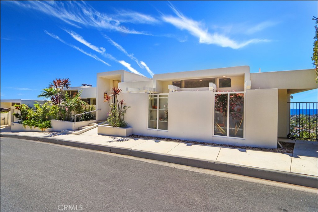 UNRIVALED PANORAMIC OCEAN VIEWS FROM EVERY ANGLE set the stage for this rare Laguna Beach escape perched high above the village. Floor-to-ceiling glass captures endless blue horizons and glowing sunsets, filling the home with natural light and an easy coastal vibe. Inside, soaring ceilings and stone floors frame an open living area anchored by a clean-lined fireplace. The newly remodeled kitchen blends quartz counters, custom gray cabinetry, and stainless appliances with a picture window that makes the ocean feel within reach. Multiple decks and terraces create seamless indoor/outdoor flow, while a private pool invites afternoon swims and evening gatherings. Generous bedrooms each open to view balconies and offer exceptional built-in storage. Spa-style baths and thoughtful details throughout keep the design timeless and practical. Huge 3rd bedroom suite / large second master suite at pool level with private entrance or access via elevator from the main floor. There is also a large storage room at pool level. Just minutes from beaches, galleries, restaurants and village shops, this home delivers privacy, style, and those jaw-dropping Laguna views in every direction.