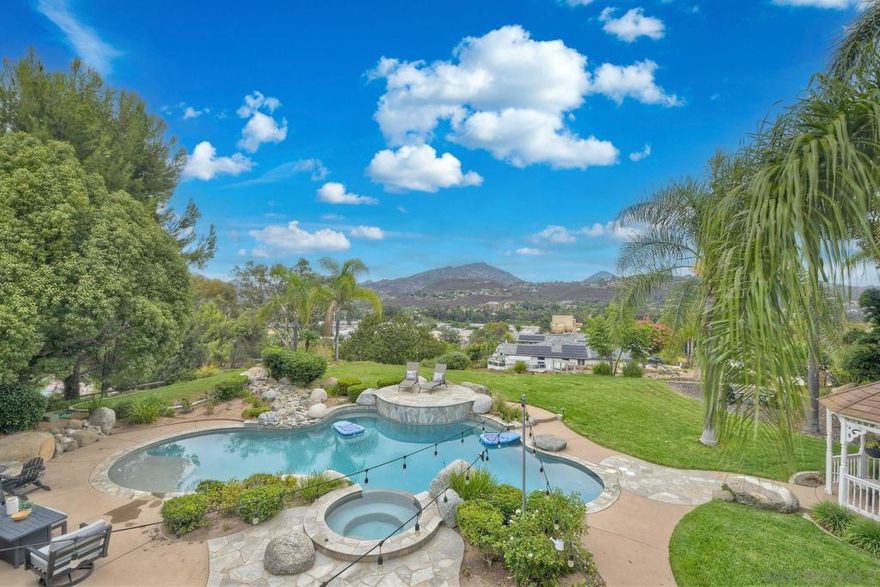 SIX Garages! One is a Large RV garage.  Custom home on private 1-acre lot in Poway w/stunning views of Mt. Woodson! Beautifully updated 4,949 SqFt home offers 4bdrm, 4ba, & exceptional indoor-outdoor living. Resort-style backyard with pool/spa, firepit and built-in BBQ. Chef’s kitchen features high-end Viking appliances. Upstairs primary suite boasts newly remodeled bathroom, walk-in closet, & private balcony. Huge bonus: oversized 3 bay, detached RV garage fits a 34’ motorhome PLUS attached 3-car garage. Owned solar No HOA or Mello Roos. PUSD  Spectacular custom home on a private 1-acre lot in Poway with breathtaking Mt. Woodson views! This beautifully updated 4,949 SqFt residence features 4 beds, 4 baths, and seamless indoor-outdoor living. The resort-style backyard includes a pool/spa, enlarged firepit, built-in BBQ, and drought-tolerant landscaping. Inside, enjoy a chef’s kitchen with Viking appliances, expansive great room with panoramic windows, and a luxurious upstairs primary suite with remodeled bath, walk-in closet, and private balcony. Thoughtful upgrades include full copper repipe, new furnace, tankless water heater, updated fascia, and more. Additional highlights: central vacuum, solid wood doors, remote blinds, abundant storage, and owned solar. RV enthusiasts will love the oversized detached garage—fits 34’ motorhome, boat, and toys—plus an attached 3-car garage. All within the award-winning Poway Unified School District. A rare, turnkey retreat—this one has it all!