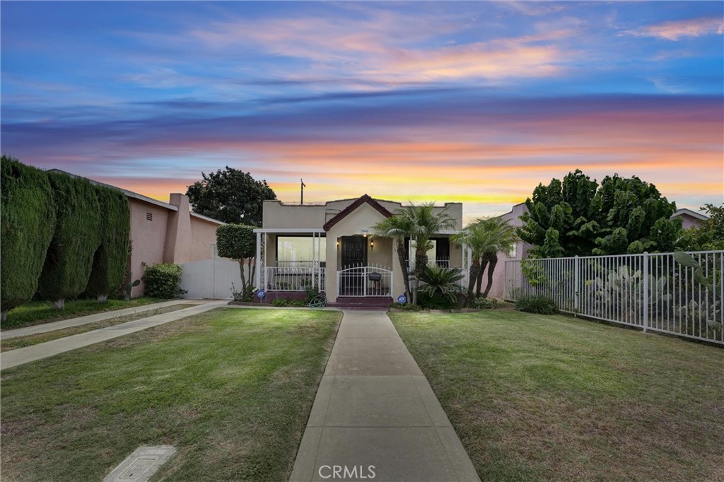 Nestled in the heart of the vibrant community of Huntington Park, 2946 Broadway offers the perfect blend of heritage charm and modern updates. This Spanish-Revival Bungalow instantly welcomes you with its freshly manicured lawn, lush landscaping, and graceful palm trees. A Spanish Colonial paneled wood door sets the tone for what awaits inside. Boasting 3 bedrooms, 1 bathroom, and 1,226 sq ft of thoughtfully refreshed living space on a generous 5,072 sq ft lot, you’ll also appreciate the convenience of a long driveway leading to a 2-car garage, ideal for potential ADU conversion. Step inside to a bright, airy great room accentuated by a striking picture window that fills the space with natural light and highlights the built-in buffet. French doors connect one of the bedrooms to a den, offering flexible living options. The additional bedrooms are spacious and versatile. The kitchen shines with newly painted cabinets, modern hardware, and tiled countertops, a perfect blend of functionality and fresh style. Throughout the home, you’ll find new luxury vinyl plank flooring, crisp fresh paint, refined baseboards, updated light fixtures, ceiling fans, panel doors with new hardware, and two AC wall units for reliable climate control. Relax in your landscaped backyard featuring mature trees, lush shrubs, and a covered patio, perfect for al fresco gatherings or afternoon respite. With garage-to-ADU potential, this home is a canvas for your future vision. Adding to its appeal, the home is just moments from Pacific Boulevard’s lively shopping and dining scene, neighborhood parks such as Salt Lake Park and Perez Park, and beloved community events including Carnaval Primavera and the Pacific Boulevard Art Walk. With quick access to the 710, 110, and 105 freeways, this home delivers both convenience and community.