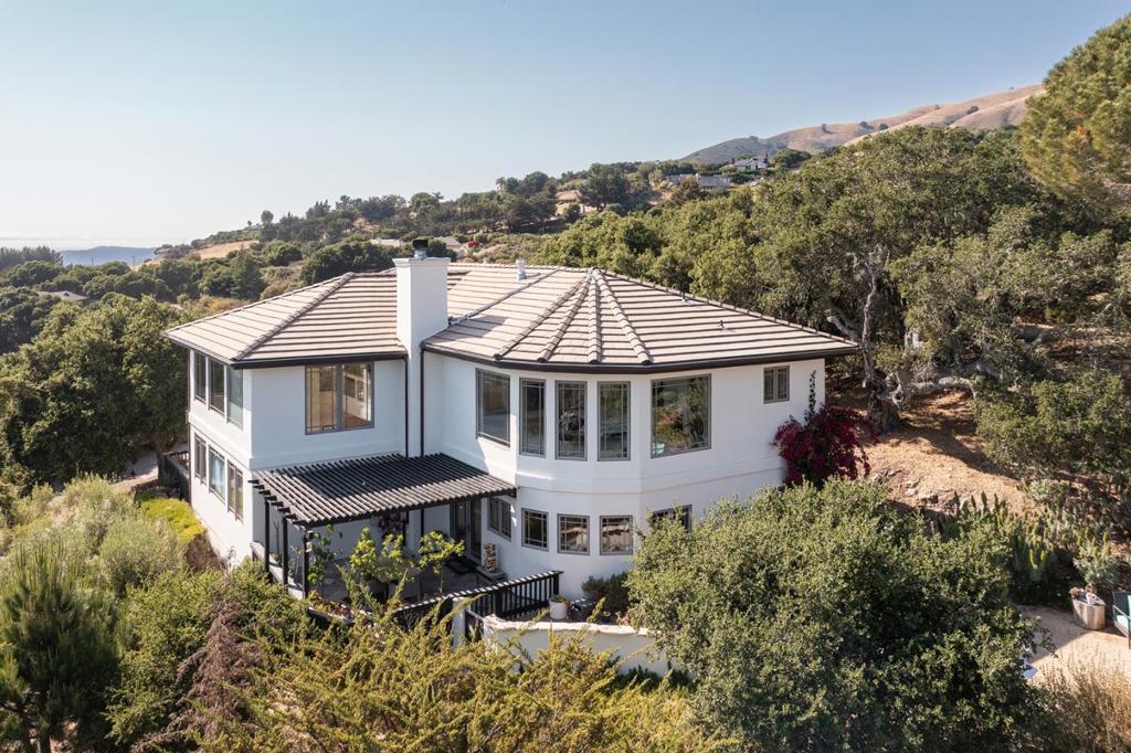 Perched on two acres with sweeping views from nearly every room, this 2005-built home offers seamless indoor/outdoor living and stunning natural light throughout. The open floor plan centers around a newly remodeled chefs kitchen with a spacious island, premium appliances, and generous pantry. The living room boasts soaring ceilings and expansive windows that frame the breathtaking landscape from the moment you walk in. Upstairs, the primary suite is a private sanctuary with floor-to-ceiling windows, fireplace, walk-in closet, and a luxurious soaking tub added by the current owners. Four additional bedrooms (including a main-floor guest room or office) and an upstairs laundry offer flexibility and comfort. With a private well and room to grow, the property invites endless landscaping or expansion possibilities. This is the essence of Carmel Valley living all in a welcoming neighborhood above the Village.