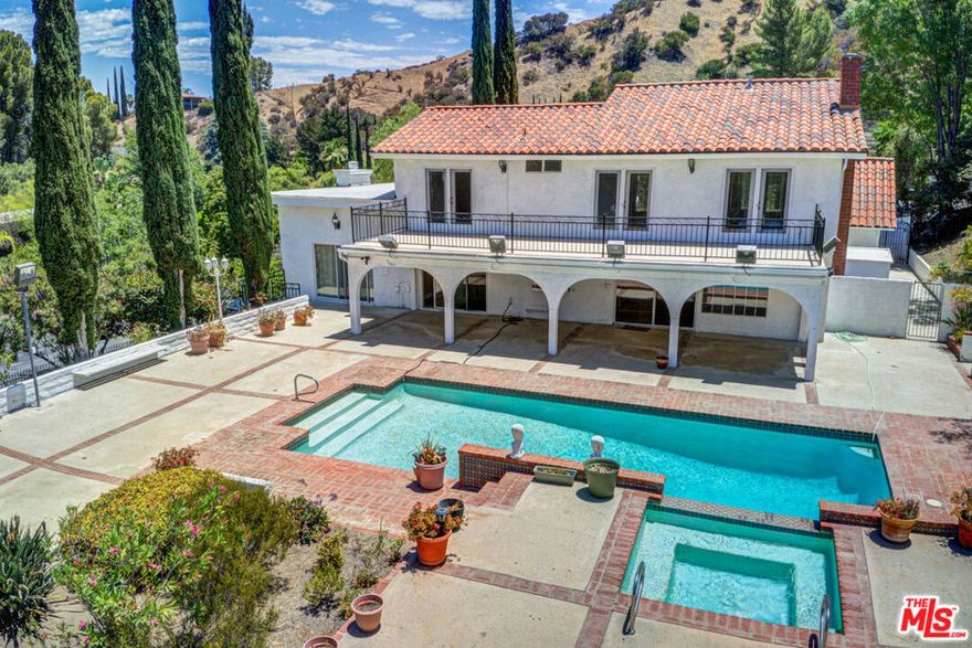 Available Now! Spacious 5 bedroom prestigious Lake Encino home with entertainer's yard, pool, and tree top views on a corner lot, high above the street. It Features 5 Bedrooms, 3 Baths, Huge Entertainers backyard with a pool and a Large covered patio and plenty of space for all your outdoor activities and parties all year long! Modern kitchen with center Island and new stainless steel appliances opens to an inviting formal dining room featuring crown molding and fireplace. Dramatic entry to a foyer with costume wrought Iron staircase which leads to four bedrooms all with wood floors, and two tastefully updated bathrooms with marble Floors. Master bedroom with an en-suite bathroom Leads to a very large balcony with amazing views. Access to the Lake Encino HOA for the use of Tennis Courts. Great local schools and shops in the area.