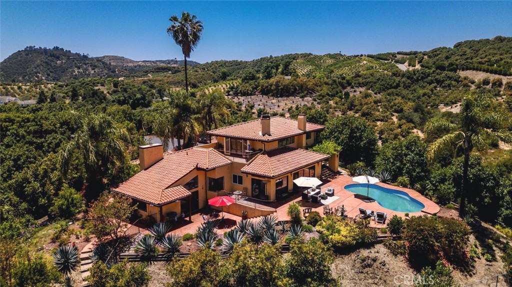 A hidden gem in the heart of Temecula’s countryside, offering privacy and tranquility. Expansive 3,354 sq ft vintage-style home with timeless architectural details and warm finishes. Spacious living and dining areas, perfect for Family/ Friends gatherings and entertaining guests. Large kitchen with classic cabinetry, ample counter space, and natural light 4 generously sized bedrooms, including a luxurious primary suite. Three well-appointed bathrooms designed for comfort and convenience. Plenty of space for gardening, outdoor recreation, or potential future development. Peaceful setting yet just a short drive to wineries, shopping, dining, and top schools. This property combines vintage charm with modern space, making it a perfect retreat or family estate. Experience the serenity and beauty that only a property of this scale can offer. Over 9 acres of land surrounded by picturesque views of rolling hills and nature, planted with over 600 Haas avocados trees. Don’t miss the opportunity to make this magical oasis your own!