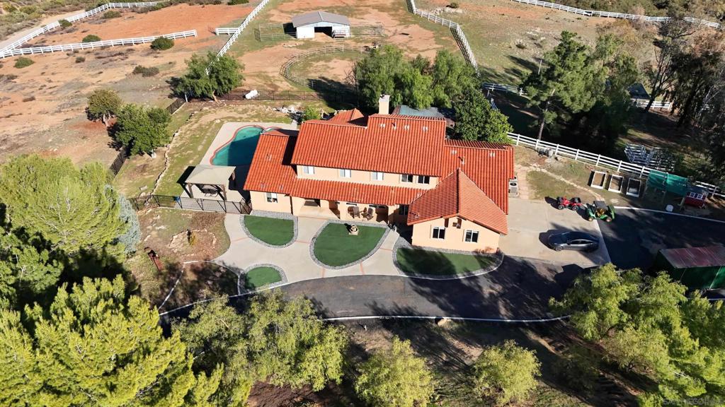 This stunning property offers a rare opportunity to embrace the California lifestyle on 10 acres of usable land. This residence boasts an array of new upgrades, making it a truly exceptional find. The home features 5 beds & 4 baths spread across a spacious 3753 sq ft of living space. As you step inside, you'll be greeted by new interior & exterior paint, as well as new carpeting that adds a touch of elegance to the interior. The property also benefits from owned solar panels, a new roof, and HVAC system, ensuring energy efficiency & comfort year-round. With a total lot size of 10 acres. For those with electric vehicles, this property offers the convenience of two level two charging stations. Additionally, a 3-car garage & a second two-car garage near the workshop provide ample space for vehicles & storage. We have septic & well inspection & Termite clearance completed Outdoors, the property is a true oasis, featuring a sparkling pool & jacuzzi, perfect for relaxation & entertainment. Embrace the agricultural opportunities with a vegetable garden, koi pond, 4 horse stable, horse corrals, livestock pens, and a chicken coop. The property also includes a large workshop for hobbyists & enthusiasts, surrounded by rolling mountains & hills, creating a peaceful & serene ambiance. Water is abundant on the property, with plenty of well water available for irrigation and home use. The property is also equipped with new pool equipment, including a propane heater & tank, ensuring that you can enjoy the pool & jacuzzi year round. The road to house has been upgraded for easy access. With a total lot size of 10 acres, this property offers ample space for outdoor activities, hiking, horseback riding and enjoying the natural surroundings. Embrace the opportunity to live amongst abundant wildlife and enjoy the quiet and peaceful setting. There's a bonus full bath in the workshop too with a shower, sink & toilet. Don't miss the chance to make this exceptional property your own and experience the best of country living in Ramona, CA. One hour from downtown San Diego, you are far enough away from the hustle and bustle of the city but still close enough to enjoy the beaches & all the fun things San Diego has to offer.