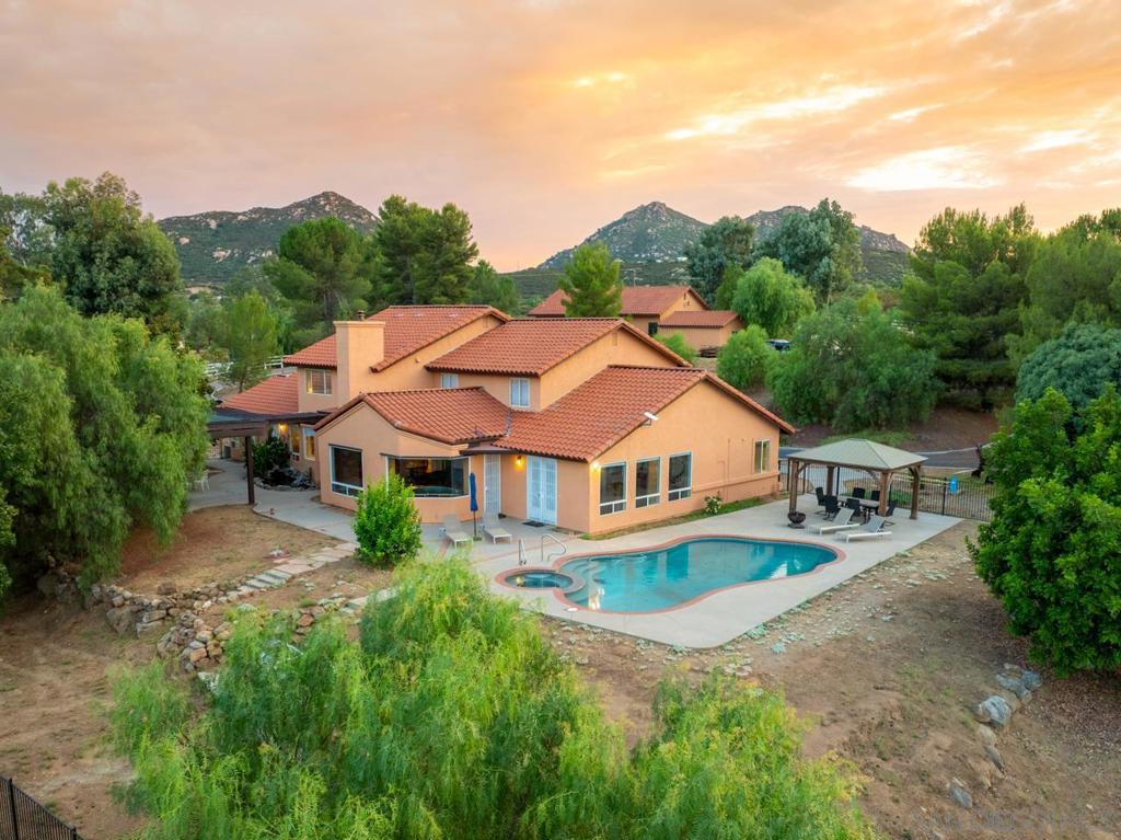 This stunning property offers a rare opportunity to embrace the California lifestyle on 10 acres of usable land. This residence boasts an array of new upgrades, making it a truly exceptional find. The home features 5 beds & 4 baths spread across a spacious 3753 sq ft of living space. As you step inside, you'll be greeted by new interior & exterior paint, as well as new carpeting that adds a touch of elegance to the interior. The property also benefits from owned solar panels, a new roof, and HVAC system, ensuring energy efficiency & comfort year-round. With a total lot size of 10 acres. For those with electric vehicles, this property offers the convenience of two level two charging stations. Additionally, a 3-car garage & a second two-car garage near the workshop provide ample space for vehicles & storage. We have septic & well inspection & Termite clearance completed Outdoors, the property is a true oasis, featuring a sparkling pool & jacuzzi, perfect for relaxation & entertainment. Embrace the agricultural opportunities with a vegetable garden, koi pond, 4 horse stable, horse corrals, livestock pens, and a chicken coop. The property also includes a large workshop for hobbyists & enthusiasts, surrounded by rolling mountains & hills, creating a peaceful & serene ambiance. Water is abundant on the property, with plenty of well water available for irrigation and home use. The property is also equipped with new pool equipment, including a propane heater & tank, ensuring that you can enjoy the pool & jacuzzi year round. The road to house has been upgraded for easy access. With a total lot size of 10 acres, this property offers ample space for outdoor activities, hiking, horseback riding and enjoying the natural surroundings. Embrace the opportunity to live amongst abundant wildlife and enjoy the quiet and peaceful setting. There's a bonus full bath in the workshop too with a shower, sink & toilet. Don't miss the chance to make this exceptional property your own and experience the best of country living in Ramona, CA. One hour from downtown San Diego, you are far enough away from the hustle and bustle of the city but still close enough to enjoy the beaches & all the fun things San Diego has to offer.