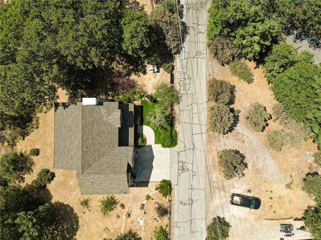 The Edge of Wonder in Deer Lodge Park!Welcome to your Lake Arrowhead escape—where adventure meets serenity in the sought-after community of Deer Lodge Park. Nestled on a nearly level lot with room to roam, this well-built and lovingly maintained home offers space for play—grown-up and kid-style alike. The welcoming front porch gives off nostalgic charm, while the ridge line views from the back deck remind you you’re exactly where you’re meant to be. Step inside to an open floor plan, featuring a true primary suite retreat complete with a luxurious bath and an incredible walk-in closet. Upstairs, you'll find two additional bedrooms, a shared full bath, and a second living space or home office—ideal for guests, work-from-home life, or cozy movie nights. Enjoy level parking, an attached two-car garage with direct entry, and just a few easy steps to the front door. The surrounding towering trees and vibrant foliage offer a natural show of color in every season, creating a peaceful and awe-inspiring setting year-round. Whether you're a nature lover, off-road enthusiast, hiker, or hunter, this location offers easy access to trails, wilderness, and quietude, all just minutes from Lake Arrowhead's heart. This is more than a home—it's your launchpad to wonder.