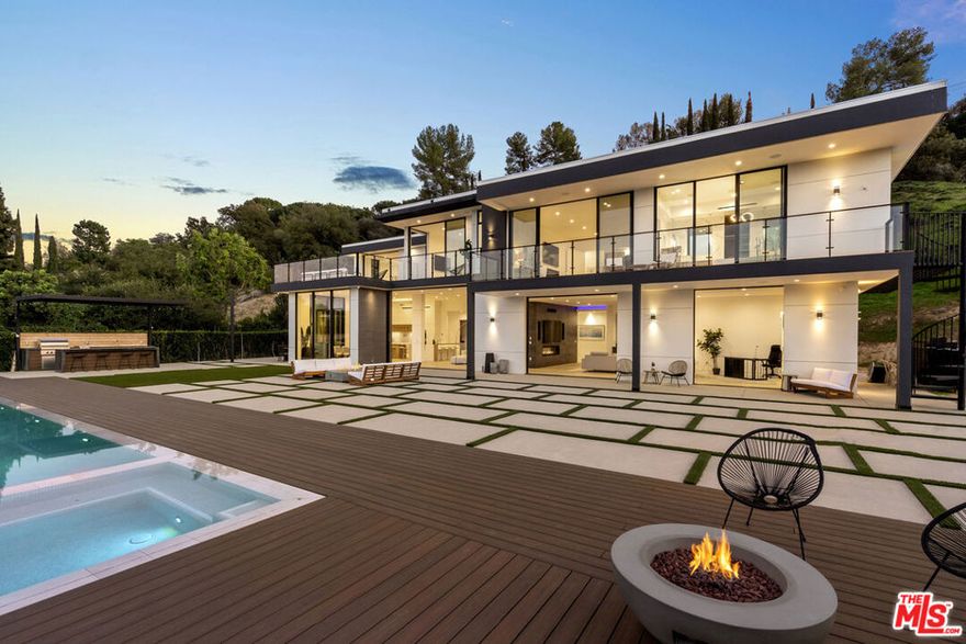 Situated on a quiet cul-de-sac south of the Blvd, down a long private driveway for complete privacy, sits this recently built modern 6 bed/8 bath masterpiece w/ unobstructed views of the city and mountains. With a sweeping open floor plan and Fleetwood doors throughout for the ultimate indoor/outdoor flow, you enter the main level through a dual-height entry that leads directly into the living room, kitchen, and dining space featuring warm interior finishes and views from every room. The family room located behind the see-through fireplace provides a cozy feeling of being tucked away, while still enjoying the openness and access to the backyard. Additional features to the main floor include butler's pantry/storage room, two en-suite guest suites, and a 2-car garage converted into a legal ADU with a kitchenette and full bath. The 2nd level features four en-suite bedrooms, all with balconies disappearing walls of glass, perfect for family or friends. The primary suite features a fireplace, desk area, expansive walk-in closet, spa-like bathroom. Enjoy the beautiful California weather in the outdoor spaces boasting a sparkling oversized infinity-edge pool, two fire pits, outdoor BBQ, and al-fresco dining areas while taking in the breathtaking views.