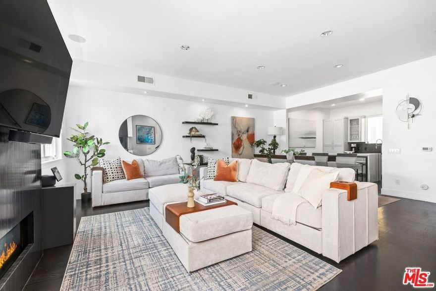 Just steps from the sand, this fully remodeled town home in the heart of Marina del Rey offers the ultimate blend of coastal living and modern design. With soaring ceilings, wide-plank wood floors, and floor-to-ceiling windows, the space feels airy and bright from the moment you enter. The main living area centers around a dramatic 250-gallon saltwater aquarium and a sleek fireplace, creating a striking focal point. The chef's kitchen is outfitted with high-end stainless steel appliances, custom cabinetry, and a stunning waterfall island perfect for entertaining. Two spacious bedrooms include spa-like en-suite bathrooms, while the upstairs loft with its own kitchenette offers flexibility as a home office, guest suite, gym, or creative space. The private rooftop deck is a true showstopper, with sweeping ocean, mountain, and city views ideal for relaxing, entertaining, or catching nightly sunsets. Other features include smart-home integration, a second fireplace in the primary suite, and two-car garage parking. All of this just moments from Venice, Abbot Kinney, and the best of Silicon Beach. Rarely does a property of this caliber, style, and location become available an exceptional opportunity in one of LA's most sought-after coastal enclaves.