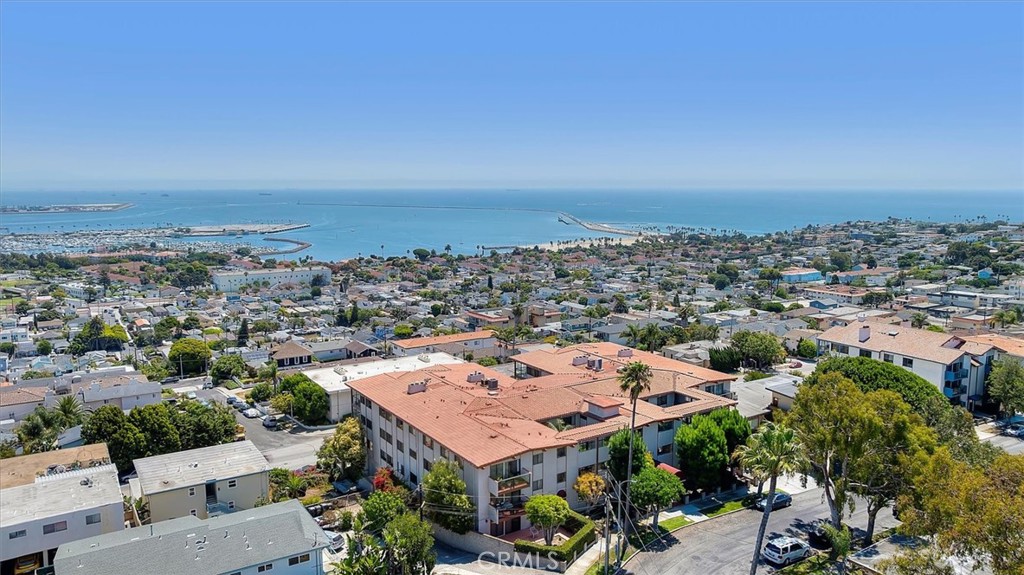 Welcome to one of the most spectacular views San Pedro has to offer! Perched high on the hill, this expansive single-story condo captures a breathtaking 180° panoramic view stretching from the Pacific Ocean to DTLA, with the harbor and sandy coastline as your centerpiece. Watch sailboats glide past the lighthouse, ships arrive and depart, and enjoy the dazzling 4th of July fireworks at Cabrillo Beach without ever leaving home. Spanning an impressive 2,388 sqft all on one level, this rare 3-bed, 3-bath home offers unmatched space and convenience; including three parking spaces and elevator access from the garage. The massive living room has a wall of windows and sliding glass doors showcasing the view, while opening to a huge 250+ sqft balcony where you can sip your morning coffee or host unforgettable gatherings. The living room offers a fireplace, wet bar, and enough room for an additional oversized dining table — truly an entertainers delight! The functional design flows beautifully to the formal dining area equipped with a long dry bar, custom drawers and glass cabinetry, and extra lighting to showcase your favorite dinnerware and gourmet dishes! The open concept carries into the remodeled kitchen with pullout drawers, stainless steel appliances, and ample counter space with granite counters and a matching backsplash slab. Down the hall and separate from the entertaining spaces, you will find three spacious bedrooms. The primary suite is a true retreat, complete with its own private balcony facing the view, dual closets, and a remodeled ensuite bathroom with dual sinks, separate soaking tub, and shower. Other highlights include hardwood floors throughout, private laundry room, fresh paint throughout, new outlets and switches, new light fixtures and fans, and 4 storage closets! The well-managed HOA comprises of lovely members that take pride in caring for the community from the beautiful tile work in the entryway, lush greenery, manicured lawn, putting green, rec room with a gym and sauna, and security cameras of the grounds that each owner has access to from their unit. Located just minutes from Cabrillo Beach, the marina, dining, shopping, and the exciting West Harbor development! Whether you love to entertain or simply relax in peace and privacy, this home offers a front-row seat to the very best of coastal living. Don’t miss the opportunity to own this one-of-a-kind property where every day feels like a getaway. This is your sanctuary; welcome home!