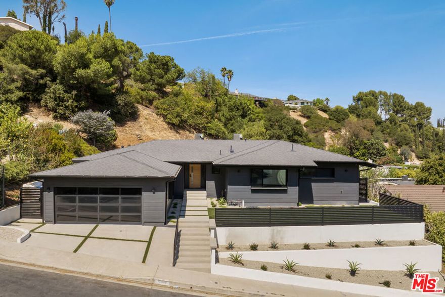 Experience an exceptionally remodeled 4-bedroom, 4-bathroom home in the coveted Sherman Oaks Hills  a contemporary oasis that feels organic, bright, and effortlessly sophisticated. Thoughtfully redesigned down to the studs, the open-concept floor plan features wide-plank wood floors, custom finishes, and a seamless indoor/outdoor flow, highlighting the desired California lifestyle. At the heart of the home, a spacious chef's kitchen with oversized center island, custom cabinetry, and professional-grade appliances opens effortlessly to the dining and living areas, creating an inviting space for both everyday living and entertaining. Expansive glass doors lead to a private backyard retreat with an expansive covered patio, outdoor lounge area, al-fresco dining, and a resort-style pool framed by hillside vistas and the city lights below. Enhancing the outdoor experience is a fully built-out private kitchen, ideal for hosting a crowd, or intimate gatherings. The primary suite offers direct access to the backyard and includes a spa-like bath with soaking tub, dual vanities, and designer finishes. The landscaped and gated front yard provides additional privacy and curb appeal. Other highlights include a family room, dedicated laundry room, and attached two-car garage. Perfectly situated just minutes to the Westside, Mulholland's private school row, and within the desirable Roscomare Road Elementary district, this home blends modern luxury with convenience in one of Sherman Oaks' most sought-after settings.