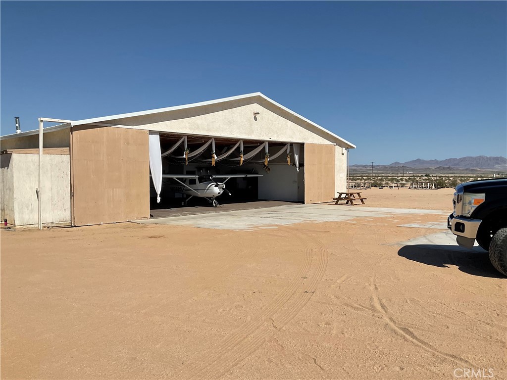 Welcome to Crosswinds Airpark, where sky meets land in perfect harmony! Nestled within the breathtaking expanse of 29 Palms, San Bernardino County, Ca with a well!! Imagine flying into your own airport with clean, fresh air and stunning views of the Starlit sky. Say goodbye to hours of traffic from LA- you're just an hour or so away from all the action. Whether you're seeking the soul stirring melodies of Coachella or the country rhythms of Stagecoach, Crosswinds Airpark serves as your exclusive gateway to these legendary events!!. This multifunctional airport offers an unparalleled opportunity for aviation enthusiasts and event planners alike. Spanning nearly 77 acres of pristine terrain that boasts FAA designation 2CA3, featuring multiple landing strips 91400 long N/S and 2600 long E/W), designed for seamless arrivals and departures. Immerse yourself in the luxury of convenience with a 300 sq. foot hangar, meticulously crafted to accommodate various functions. From intimate gatherings to grand celebrations, the hangar's versatile design caters to every occasion, complete with essential amenities including a fully equipped kitchen, luxurious bath and cozy sleeping quarters. With clear blue skies and optimal flying conditions year-round, this haven promises an unrivaled aviation experience. Perfectly situated amidst the allure of Palm Desert and the vibrant energy of Palm Springs and Las Vegas, Crosswinds Airpark offers more than just a gateway to adventure- it's a sanctuary of possibility! Great location for your Desert fun adventures and close to the entrance of Joshua Tree National Park and Military Base. Enjoy breathtaking panoramic views from every angle...sweeping vistas of open skies, rolling hills, and natural beauty as far as the eye can see. Whether sunrise or sunset, every moment feels like a masterpiece! Located just off Amboy Rd. 3 miles from the city of 29 Palms...your private Desert Paradise awaits you!!