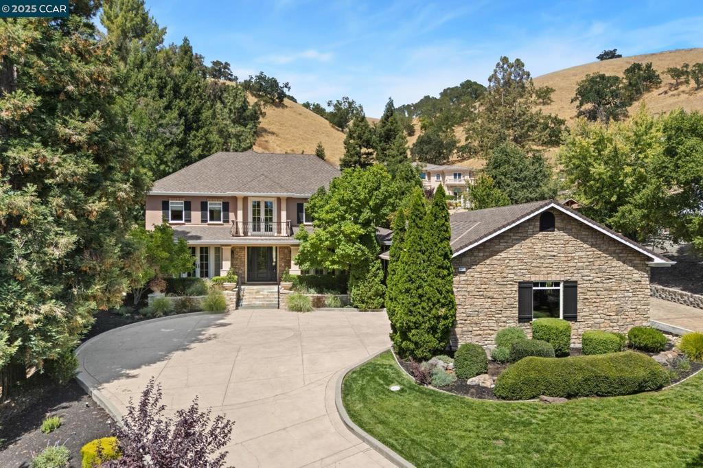 Set on nearly 1 acre in prestigious Diablo Country Club, this exquisitely crafted estate features 5 bedrooms, 5.5 bathrooms, & exceptional custom details like hardwood floors, extensive millwork, & coffered ceilings. Formal living and dining rooms create elegant entertaining spaces, while the gourmet kitchen delights w/ top-tier appliances, custom cabinetry, an expansive island, & an inviting breakfast nook. The adjacent family room opens seamlessly to the beautifully landscaped yard. The well-appointed main-level guest suite is accompanied by an additional half bath. Upstairs, the luxurious primary suite boasts vaulted box beam ceilings, a spacious walk-in closet, & a spa-like bath w/ heated floors, steam shower, & dual vanities w/ custom cabinetry. All bedrooms are en suite, ensuring privacy and comfort. Additional amenities include a dedicated laundry room, expansive finished lower-level basement w/ storage rooms or potential climate-controlled wine cellar, large 3-car garage, backup generator, Tesla charger, & mudroom w/ built-in storage. The grounds feature multiple outdoor seating areas, a firepit, outdoor kitchen & bar w/ natural gas BBQ, a remote-controlled waterfall, & lush landscaping. Located within the top-rated San Ramon Valley School District in the heart of Diablo.