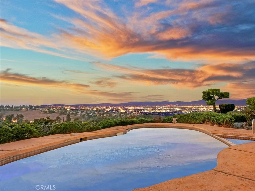 Behind the exclusive gated community of Rolling Hills lies a property of rare distinction—an expansive private sanctuary offering over two lush acres with commanding, unobstructed 180-degree views that stretch from Malibu’s coastline to the twinkling lights of Long Beach. This is not just a home, but a once-in-a-generation opportunity to own a legacy estate in one of Southern California’s most coveted communities.



The single-level residence, designed in the mid-century modern tradition, carries a timeless character with details that celebrate an era of artistry and elegance. A circular dining room, sunken living room with a built-in custom mohair sofa and baby grand piano, original terrazzo floors, warm wood paneling, and metallic wallpaper evoke the glamor of the 1960s—inviting a discerning buyer to reimagine and restore while preserving its history.



With seven bedrooms—including five ensuite baths—the home offers extraordinary flexibility for family, guests, or multigenerational living. Nearly every room frames panoramic vistas, blending indoors and outdoors in seamless harmony. Additional features include two large living spaces, a dedicated dining room, a kitchen with breakfast nook, and an attached ADU complete with bedroom, bath, kitchenette, and its own living and dining areas.



The grounds are equally inspiring. A serene front garden with a tranquil fountain welcomes you, while the backyard reveals endless potential. The existing pool is perfectly sited to capture the sweeping city and ocean views, offering the chance to transform it into a stunning centerpiece for outdoor living and entertaining. A horse corral and abundant usable land provide room for expansion, equestrian pursuits, tennis or pickle ball courts or simply enjoying the peace and privacy of the acreage. Mature fruit trees—avocados, persimmons, and sweet orange and grapefruits—enrich the property with a sense of retreat and abundance.



The driveway is thoughtfully set back from the main road, offering an added layer of privacy and protection from sound, while the sought-after Crest Road gate ensures effortless access in and out of the community—an uncommon convenience in Rolling Hills. Opportunities of this scale, location, and character in Los Angeles County are exceedingly rare. More than a home, this estate represents a legacy—a canvas for creating a truly spectacular residence to be cherished for generations.