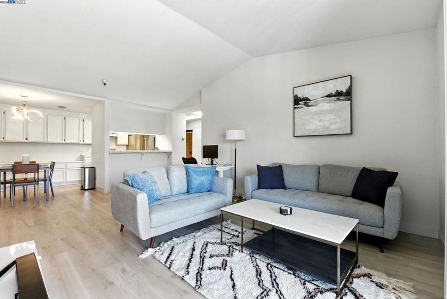 Welcome to Unit 405 at 1400 Carpentier Street — a bright and spacious top-floor condo in the heart of downtown San Leandro. This oversized one-bedroom unit offers nearly 940 square feet of well-designed living space with a smart layout that feels both open and inviting.  Natural light pours in through skylights and large windows, highlighting the open-concept living and dining area. A cozy fireplace anchors the space, perfect for relaxing evenings at home. The kitchen features a casual eat-in area, and the in-unit laundry adds everyday convenience.  The bedroom comfortably fits a king-size bed and offers generous closet space. You’ll also appreciate the full bath with updated fixtures and clean finishes.  This secure, elevator building includes gated garage parking and is just steps from BART, shops, and some of San Leandro’s best local restaurants like Paradiso, Top Hatters Kitchen, and Sons of Liberty. Plus, you’re minutes from 580 and 880 — making commuting around the Bay easy and efficient.