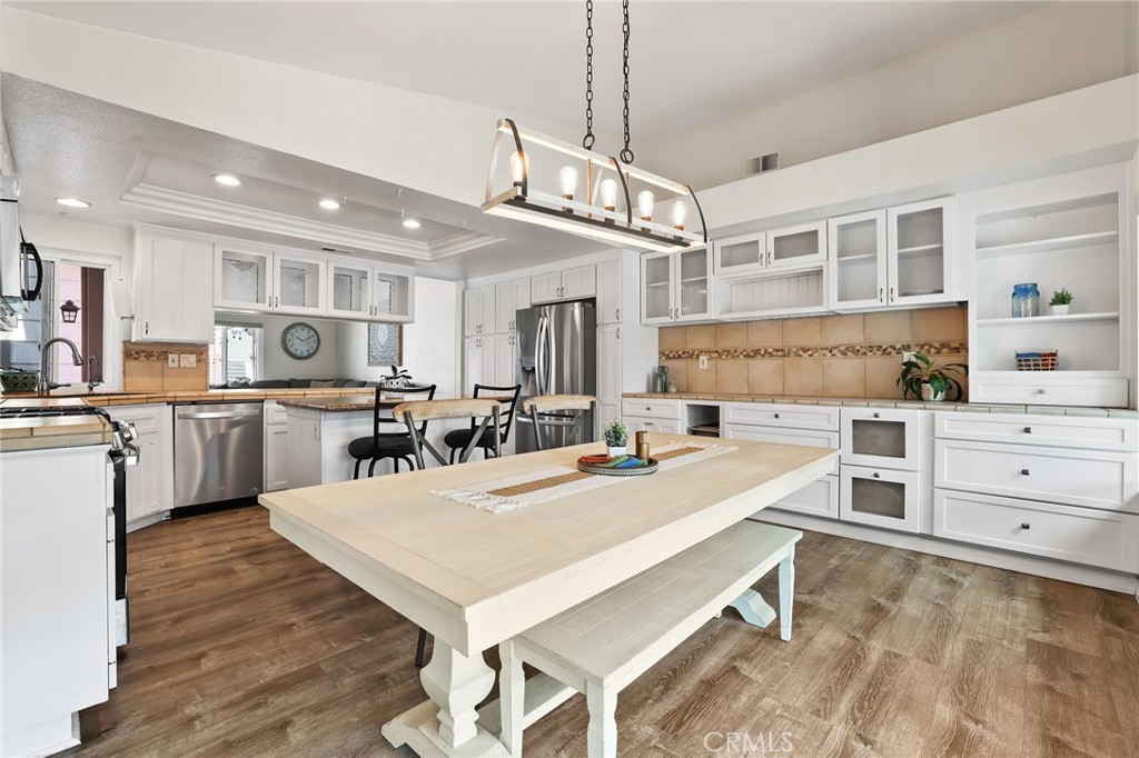 Darling one-story coastal home on private cul-de-sac. Charming courtyard opens to upgraded interior with vinyl plank flooring and vaulted ceilings. Spacious kitchen features stainless appliances, granite counters, farmhouse sink, and dining area. Wrap-around bonus room offers space for gym, playroom, and more. Backyard includes fruit trees, patio, privacy, and a lawn. Primary suite offers walk-in closet and upgraded dual vanity bath with soaking tub and modern shower. All this, just minutes from everyday conveniences!