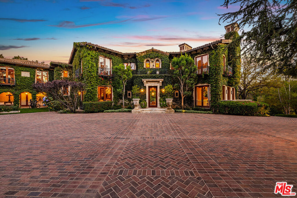 The Leonard Estate stands as the most important legacy property on the Westside - an extraordinary Italian villa of rare scale and pedigree, available once in a generation. Envisioned by world-renowned architect Richard Landry, this Florentine-inspired masterpiece was crafted with only the finest materials and exudes timeless elegance. Perched on nearly two acres of expansive, park-like grounds within the prestigious Palisades Riviera, the estate is hidden behind double gates, towering hedges, and a long private driveway, ensuring complete privacy and security. The ivy-clad facade opens to a grand motor court and sets the stage for over 16,700 square feet of exquisitely designed interiors. Vaulted ceilings, generous proportions, and seamless indoor-outdoor flow create a setting that is equally suited for intimate living or entertaining on a grand scale. The main residence features a dramatic two-story family room, a refined formal living room and dining room, a solarium, a gourmet kitchen with professional appliances and center island, and multiple wings devoted to leisure and entertaining, including a screening room, media room, and gym. There are seven bedrooms in total, with the primary suite serving as a private retreat offering a fireplace, spa-like bath, dressing rooms, and a terrace overlooking breathtaking ocean, canyon, and mountain views. The grounds are a world unto themselves: a sun-drenched oval pool and spa, lit tennis court with viewing pavilion, rolling lawns, meadow, putting green, and lush gardens framed by mature trees. A full two-story guesthouse adjacent to the pool includes a kitchen and guest accommodations, ideal for hosting visitors or poolside gatherings. The Leonard Estate is a true world-class residence that combines European romance with modern luxury, offering both sumptuous and serene living on one of the Riviera's most coveted streets.
