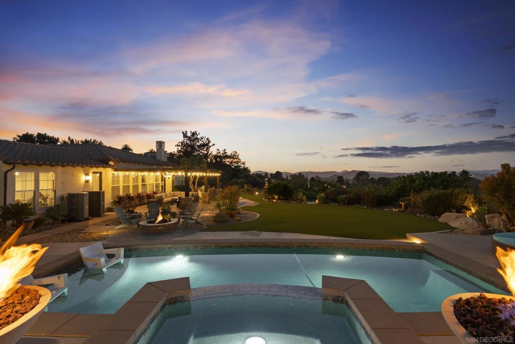 Tucked within the gated prestige of Old Coach Collection, this single story estate with ADU, offers a life of privacy, sweeping canyon and mountain vistas, and effortless entertaining. The setting feels both serene and connected, with Maderas Golf Club moments away and the beauty of rolling hills all around. Outdoor living takes center stage. A sparkling pool and spa are framed by generous patios designed for gatherings, while a built-in barbecue area invites long afternoons that linger into starlit evenings. Lush landscaping and a dedicated dog run add both beauty and function, ensuring every member of the household has space to enjoy. Inside, the residence has been thoughtfully remodeled to reflect timeless elegance rather than fleeting trends. Sunlit living spaces flow toward the outdoors, creating natural venues for hosting. The kitchen is the heart of the home, with modern updates that balance sophistication and practicality. A one-bedroom ADU provides flexibility for guests, extended family, or private office retreat. The primary suite offers a sense of quiet sanctuary, elevated by its views of the canyons beyond. Every room is designed to frame the natural beauty that surrounds, bringing the outside in at every turn. This Old Coach estate is more than a home, it is a private haven for those who value refined entertaining, everyday comfort, and the prestige of living near one of San Diego’s most celebrated golf clubs.