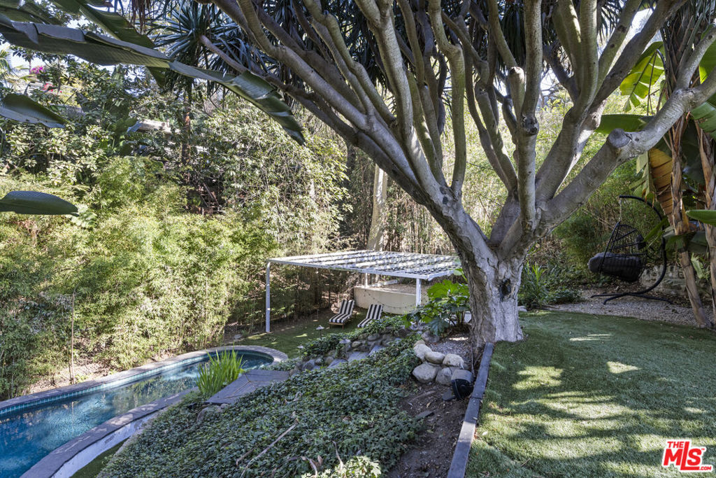 Bohemian Modern Oasis | Private View Compound West of Runyon Canyon, Perched atop its own secluded plateau just west of Runyon Canyon, this one-of-a-kind 3BD, 3BA designer residence offers over 12,000 sq ft of private grounds, a rare fusion of architectural style and serene outdoor living. Meticulously renovated with uncompromising attention to detail, the home features Pella solid wood windows, Lutron smart switches, a full security suite, and an integrated entertainment system in the primary suite. Every material and finish reflects a level of craftsmanship typically reserved for the highest caliber estates. Designed for seamless indoor-outdoor living, the expansive terraced grounds feature multiple entertaining areasincluding a warm fire pit lounge, sprawling grassy yard for al fresco dining, and a secluded lower-level pool wrapped in lush greenery reminiscent of the Viceroy's tropical hideaways. A true Bohemian Chic escape, blending tranquility with bold design.