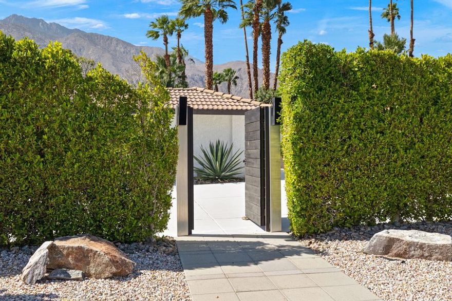 Welcome to your LIFESTYLE dream home in the iconic Movie Colony area of Palm Springs. This 4-bedroom, 4-bathroom residence offers a stylish, modern living space, custom-designed for both relaxation and entertainment. Nestled on a large corner lot, this property boasts exceptional mountain views and an expansive outdoor entertainment patio, citrus trees and lawn area. Step inside to discover an open great room where the kitchen, dining, and living areas seamlessly blend, highlighted by a gas wood burning fireplace. The open u-shape kitchen counter surrounding a standalone center island is a chef's dream providing ample space for culinary creativity including a casual breakfast/dining counter. Two primary bedrooms with private bathroom ensuites offering luxurious retreats with direct access to the pool and shaded outdoor patio, while two additional guest bedrooms offer adjoining full-suite bathrooms affording comfort and flexibility for family and visitors. Outdoor living, entertaining in the Palm Springs lifestyle with a sparkling pool, relaxing spa, accented by a stone wall feature waterfall and firepit perfect for gatherings under the starlit desert sky. The outdoor cooking center invites dining year-round. Parking is a breeze with a 2-bay garage plus additional open parking space for guests. The home's well-designed layout includes a laundry room with 2 sets of washers and dryers and an adjacent private large storage room. Conveniently located near the vibrant Palm Springs city center, popular restaurants, nightlife and Palm Springs International Airport, this home is your private oasis in the heart of the desert. This is the opportunity to make this spectacular property your own.