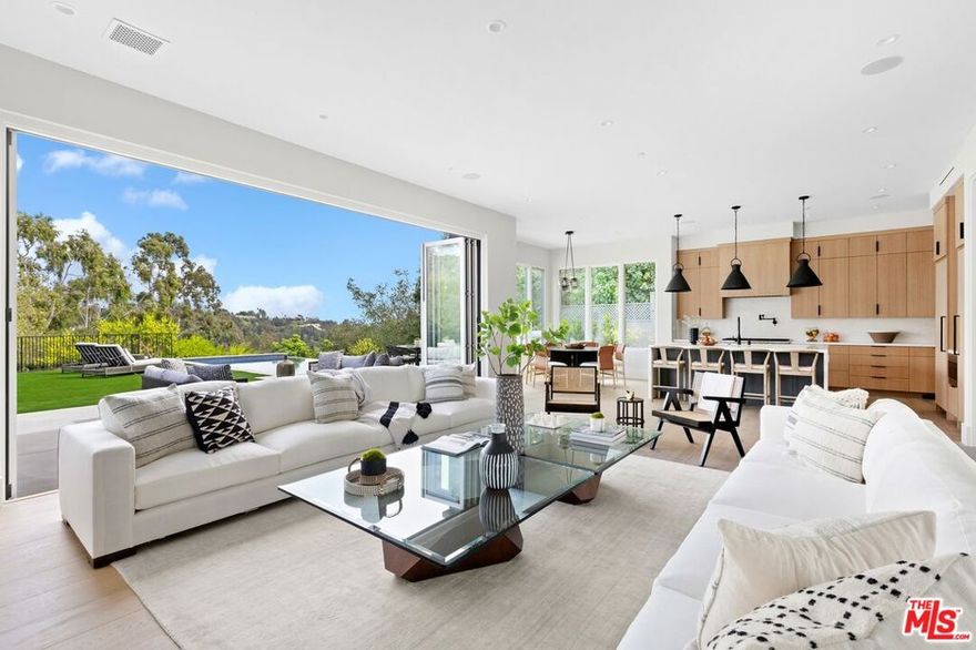 Brand New stunning Ca. Coastal design with contemporary finishes envisioned by renowned architect Ken Ungar. Spanning an impressive 7,167 square feet, this luxurious home boasts 6 bedroom suites, 2 additional half bathrooms, a gym/yoga room, game room, and a private movie theater. The indoor/outdoor flow is superb, while the tranquil 16,000+ square foot lot in Brentwood ensures privacy and serenity. Surrounded by mature trees, the expansive backyard features an infinity pool, spa, barbecue, and a lounge area with a fire pit, offering an idyllic spot to revel in the canyon and hillside vistas. Whether seeking relaxation or stylish entertainment, this home caters to all.Upon entering, the main level welcomes you with a spacious living room, formal dining room, powder room, sunlit family room, and a well-appointed kitchen with scenic views and direct access to the picturesque backyard. Throughout the residence, 10" European oak hardwood floors exude timeless elegance. The kitchen is a chef's dream, complete with a butler's bar, breakfast area, custom cabinetry, walk-in pantry, Wolf range, built-in microwave, Asko dishwasher, and Thermador fridge and freezer. An office and a separate guest suite also reside on this level, offering convenience and versatility.Ascending to the upper level, you'll find a cozy den with panoramic views, serving as a relaxing retreat. Additionally, there are 3 secondary suites with generously sized bedrooms, impeccable bathrooms, and ample closets. The expansive primary suite impresses with vaulted ceilings, a romantic fireplace, his and her walk-in closets, a luxurious spa-like bathroom, and a balcony overlooking the backyard, where towering trees and the canyon create a captivating backdrop.Designed to embrace its hillside location, the lower level features floor-to-ceiling glass, flooding the space with natural light and providing breathtaking treetop vistas. This level offers easy access to the side and back yards and encompasses a guest suite, a temperature-controlled wine room, a bar, a spacious gym/yoga room, a game room, a powder bathroom, and a home theater.This extraordinary residence epitomizes contemporary luxury living. With its impeccable design, stunning amenities, and prime location, this home offers a lifestyle of unparalleled elegance and comfort.