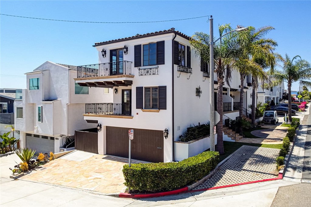 A soulful Spanish on Alma! This beautifully refreshed ocean-view townhome enjoys a corner lot at the peak of the hill. You’ll find cheerful, tasteful and authentic Spanish style, featuring colorful tiles, wrought iron and saltillo tile flooring. There’s a wonderful open floorplan on the top level, with lots of windows, natural light and ocean views from the oversized living room and generous balcony. A large, central kitchen island offers plenty of storage and casual dining space, while a separate dining area offers a space for more formal meals. Gleaming hardwood flooring with brand-new, luxurious walnut finish accentuates the beauty of the top floor. All bedrooms are ensuite and feature walk-in closets. The primary boasts separate shower and soaking tub. The lower bedroom is uncommonly large compared to similar townhomes. The entire building is freshly painted outside, along with the living spaces. Modern lighting, air conditioning and 4-car private parking round out the features of this move-in-ready dream home. Location is just steps from the North End’s cluster of restaurants, shops and services – Manhattan Beach’s “second downtown” – and convenient to Grand View elementary. If you’ve been waiting for a gem to come along that checks all the boxes and invites you right in, you’re in luck. Here it is!