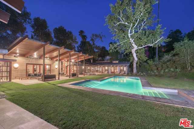 An architectural tour de force, this gated contemporary is a sanctuary, combining dramatic space and light with absolute privacy on incomparable grounds. Designed by Peter Tolkin Architecture and built in 2001, the residence is set on over 3 secluded acres on a serene hillside above the San Fernando Valley. Shaded by a roof with deep overhangs, the main residence is a series of concrete and glass pavilions that open to a peaceful courtyard, pool, spa and lush landscaping, with stately oaks, sycamores, fruit trees, palms and succulents. Quality design, construction and finishes. Secluded one-bedroom guesthouse with kitchen, separate artist's studio/gym with full bath and N/S lighted tennis court complete this rare, exquisite estate.