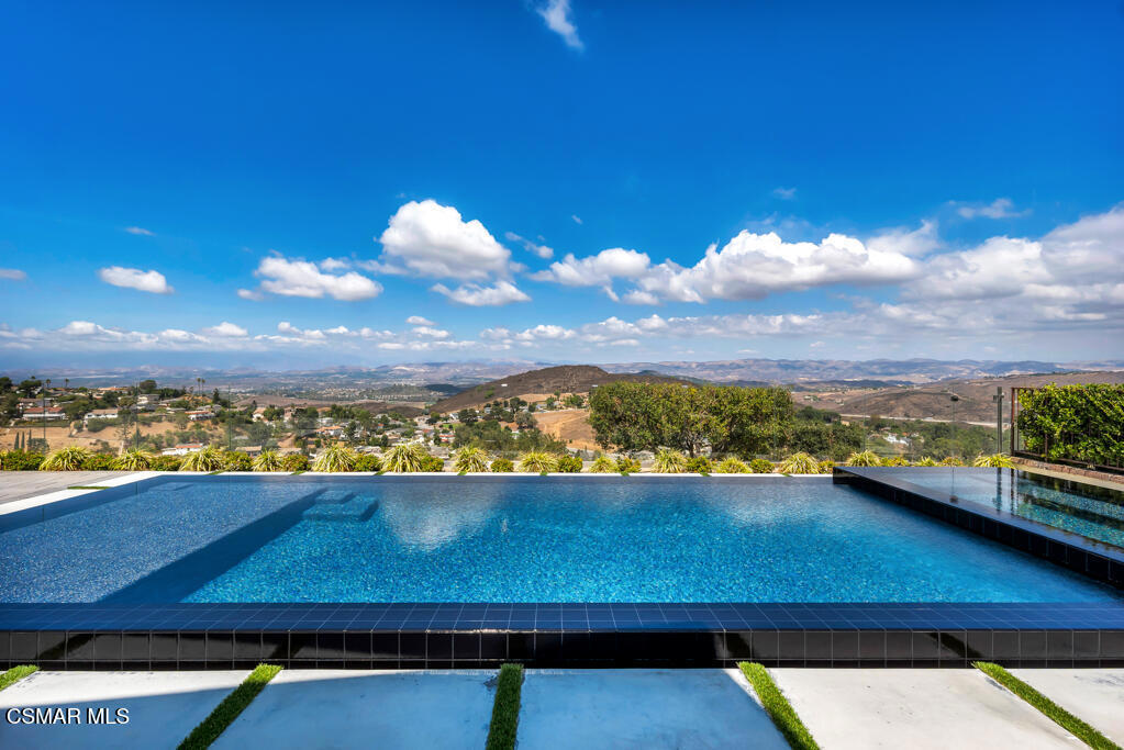This rare north-facing lease with unparalleled over-the-top unobstructed panoramic mountain views is available fully furnished/stocked for a bring-your-clothes move-in-ready experience, as well as an option as a vacant rental. Overlooking the Sunset Hills Golf Course from above, this opulent home showcases timeless design, exceptional craftsmanship, and energy efficiency. Step through the rich mahogany-etched glass double front doors, and you are greeted with French Oak Hardwood flooring and Dual-Pane Milgard windows, which bathe the interiors in natural light. Smooth ceilings, recessed lighting, and raised panel interior doors lend a refined sophistication throughout. The inviting downstairs layout includes a double-door entry to a main floor bedroom with an attached full bath. An open-concept design seamlessly unites the kitchen, family room (with a stunning custom electric/heating fireplace), dining room and pool table room for an expansive gathering space. The gourmet kitchen is a true centerpiece, showcasing porcelain countertops, decorative backsplash, white shaker cabinets, Wolf Stainless Steel appliances and recessed lighting highlighted by over the island pendant lights. The large waterfall island features a built-in sink, Insta-hot/cold water dispenser, and electrical outlets on both sides, giving ample space for easy meal prep and intimate gatherings. A striking glass-paneled staircase guides you to the upper level with incredible panoramic views from every bedroom, seeing snow-capped mountains in the winter and amazing sunsets year-round. The primary suite creates a luxurious retreat featuring a full wall of built-in cabinets for additional closet space, highlighted by an extra-large built-in TV, The spa-inspired primary bath is complete with an oversized travertine shower, soaking tub, porcelain counters, modern fixtures, and a custom wardrobe system featuring pull-out drawers. The two secondary bedrooms are sizable, with one currently being used as an office. A well-appointed hallway bath with dual shower heads accommodates the secondary bedrooms. Two oversized glass sliding doors provide effortless access to the backyard resort-style oasis, highlighted by a four-sided zero-edge pool / raised spa finished with extremely rare glass like Jewelscape and clad in sleek black tiles for a dramatic modern look. Gorgeous pavers lead out to the Transparent glass panel back walls, ensuring both comfort and uninterrupted vistas. Designed for entertaining, the outdoor granite counter kitchen includes a professional-grade 36' Twin Eagles 36'' Stainless Steel BBQ, refrigerator, sink, and a signature Big Green Egg XL Kamado Cooker. When entering the property from the street, you experience the expansive paver driveway, surrounded by roses of all colors, plush landscaping with large mature trees, and a custom three-car garage that is equipped with a Tesla Charger and ample storage cabinets. When remodeled, the home was designed with ease of control, with everything, including a Google Seven-Camera security system, an iAqualink Pool/Spa Controller, a SONOS Eight-Station sound system, a Nest 3-Zone Heating/AC, and a Rachio landscape watering system. All systems can be controlled through apps on your mobile phone for complete ease. The house is also equipped with 29 solar panels and five Tesla backup batteries, a soft water system throughout, a Tankless Hot water system for endless hot water and a hot water circulation system, and a new 220-volt Electrical Panel, all designed for minimal utility costs and increased efficiency. Tucked at the top of a quiet cul-de-sac at the end of the development, this home blends charm, sophistication, top-level technology, and an enviable location--embodying the very best of California living.