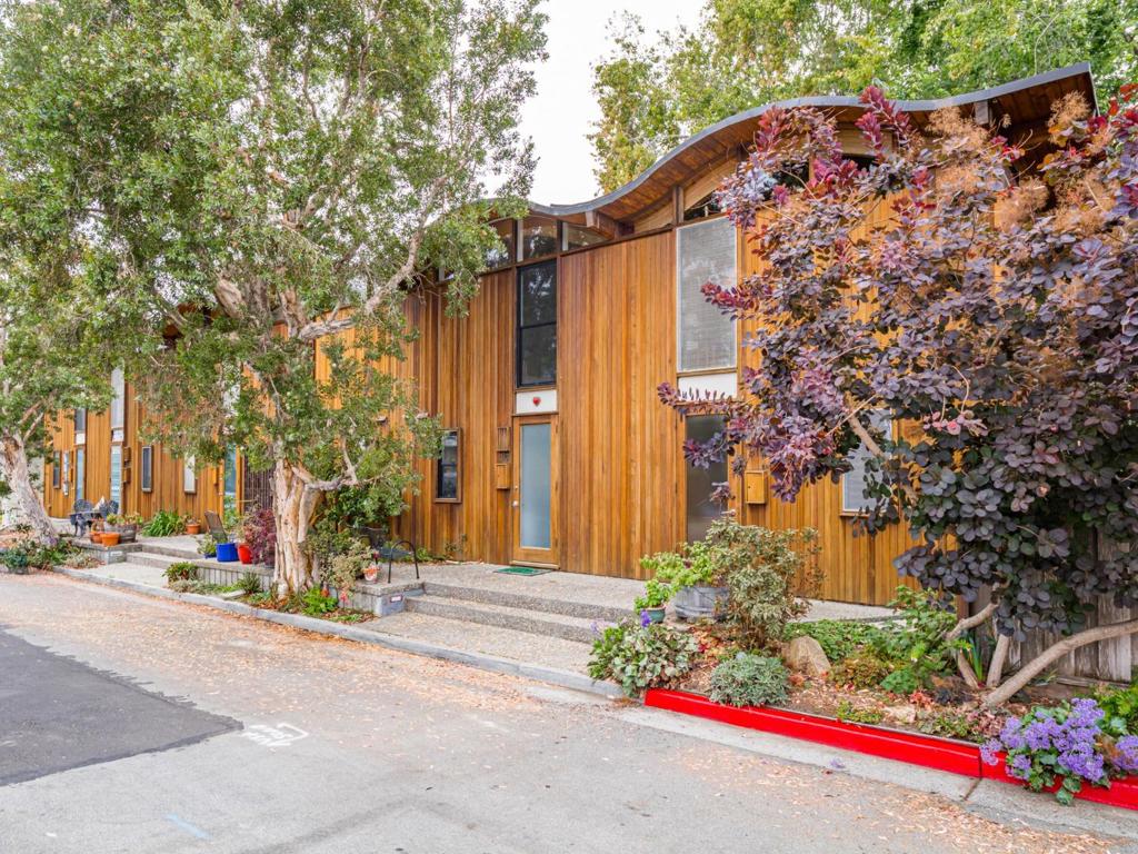 Welcome to this 2-bedroom Townhome located in the vibrant city of Santa Cruz. A short walk to the sand at Seabright Beach, Tyrrell Park, and downtown. The 6 unit complex has won numerous architectural awards for its wavy-roof design and stunning tall windows overlooking lush trees and was featured in Sunset Magazine. The kitchen is equipped with modern appliances, including an electric cooktop, oven range, dishwasher, and refrigerator, tile backsplash and a pantry for additional storage. The living room features a dining area, Italian light fixtures, and a "floating" fireplace. Gorgeous tile flooring throughout ensuring durability and ease of cleaning. Spiral staircase brings you to the upstairs area with 2 bedrooms with California closet shelves. The 2nd bedroom is a loft style, which is perfect for a work-at-home office / guest room. The updated bathroom features a stall shower and is graced with beautiful Sea colored tiles. This home provides comfortable living with essential amenities in a celebrated coastal location. There is a private driveway providing access to the one car garage and spacious storage, also includes access to the community laundry room with a washer and dryer. A private rear deck overlooks the seasonal creek for alfresco dining.