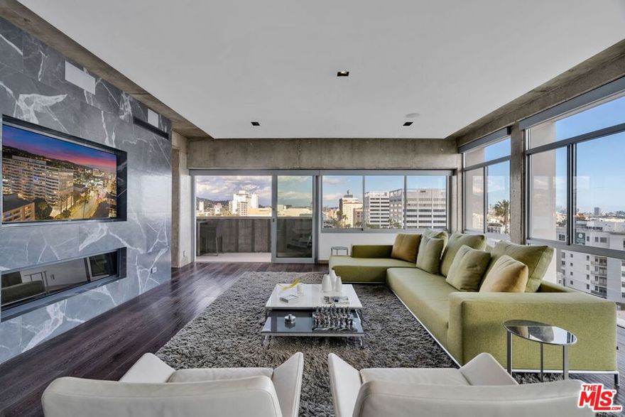 Imagine for yourself an enviable lifestyle of luxury and convenience. This immaculate full-service, luxury hi-rise prominently featured on hit TV shows, Hollywood Versailles Tower is situated in the most famous locale on planet Earth: Hollywood, California. Your claim to this remarkable property is Residence 802, situated in the premier line of the building, flaunting irreplaceable Eastern city lights views towards LA's Times Square: Hollywood & Highland, and massive Southern views across the basin. Rebuilt by its present owner with unrivaled quality and craftsmanship, this condominium space has been masterfully designed from a legal two-bedroom into an oversized one-bedroom. Your kitchen is a chef's showpiece featuring appliances by Sub-Zero and Wolf, which complement the hand-crafted custom cabinetry and showstopping book-matched Blackhorse marble island with waterfall edges and a bar counter. Each bathroom boasts Franz Viegener plumbing fixtures, tasteful Gallery Glass tiling from Ann Sacks and black Marquina granite, reminiscent of an opulent resort. The soundproofed flooring is covered by seven-inch plank, engineered, wire-brushed Duchateau Oak wood floors. Your private balcony awaits just beyond a pair of matching Fleetwood sliders that glide apart to reveal the pulse of Hollywood Boulevard. When it is time to wind down, motorized shades effortlessly close with a simple request to 'Alexa', and the built-in surround sound system comes to life, while you relax in front of the Amantii heated fireplace. European 'Nora' lighting fixtures allow you to customize your lighting settings to fit the mood. Lutron dimmers control nearly every light fixture. Laundry hookups are installed in a discreet closet. No expense was spared to create this professionally-designed residence. Hollywood Versailles Tower welcomes residents with a modern, redesigned lobby, 24-hour doorman/concierge and valet parking. Also included outside are a heated, remodeled outdoor pool and sundeck with barbecue and fire pit, a fitness center, dog run, electric vehicle chargers, and a multi-purpose recreation room. Hollywood Versailles Tower holds significant reserve funds. The quality and luxury of this property can only truly be experienced in person. Please call for a private appointment, no open houses are planned.